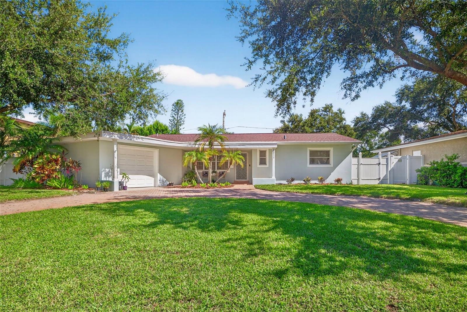 Welcome to this charming full-block home in the highly sought-after Jungle Prada neighborhood, featuring a perfect blend of architectural character and modern updates. This beauty features 3 bedrooms, 2 full baths, and 1,618 square feet of living space, that is thoughtfully designed to provide both comfort and functionality. From the moment you arrive, the oversized one-car attached garage, circular driveway, and welcoming covered front porch create a warm first impression. Inside, the open layout is enhanced by updated lighting, ceiling fans, and durable laminate flooring that flows seamlessly throughout the home. The kitchen is a true standout, showcasing granite countertops, stainless steel appliances, and ample cabinetry—ideal for both everyday meals and entertaining. Additional highlights include a large laundry room with extra storage, a versatile study/flex space perfect for a home office or creative studio, and newer windows that bring in abundant natural light. The spacious bedrooms and updated bathrooms complete the home’s inviting interior. Large backyard with plenty of room to enjoy the outdoors and is located just 2 doors down from a private entrance to Abercrombie Park, and is minutes away from Doc Fords, Walter Fuller Park, specialty waterfront dining, shopping, and all the best of the St. Petersburg's lifestyle and Florida's award winning gulf beaches. Combining classic curb appeal with modern conveniences, this home sits high and dry and is an exceptional opportunity in one of the area’s most charming neighborhoods.