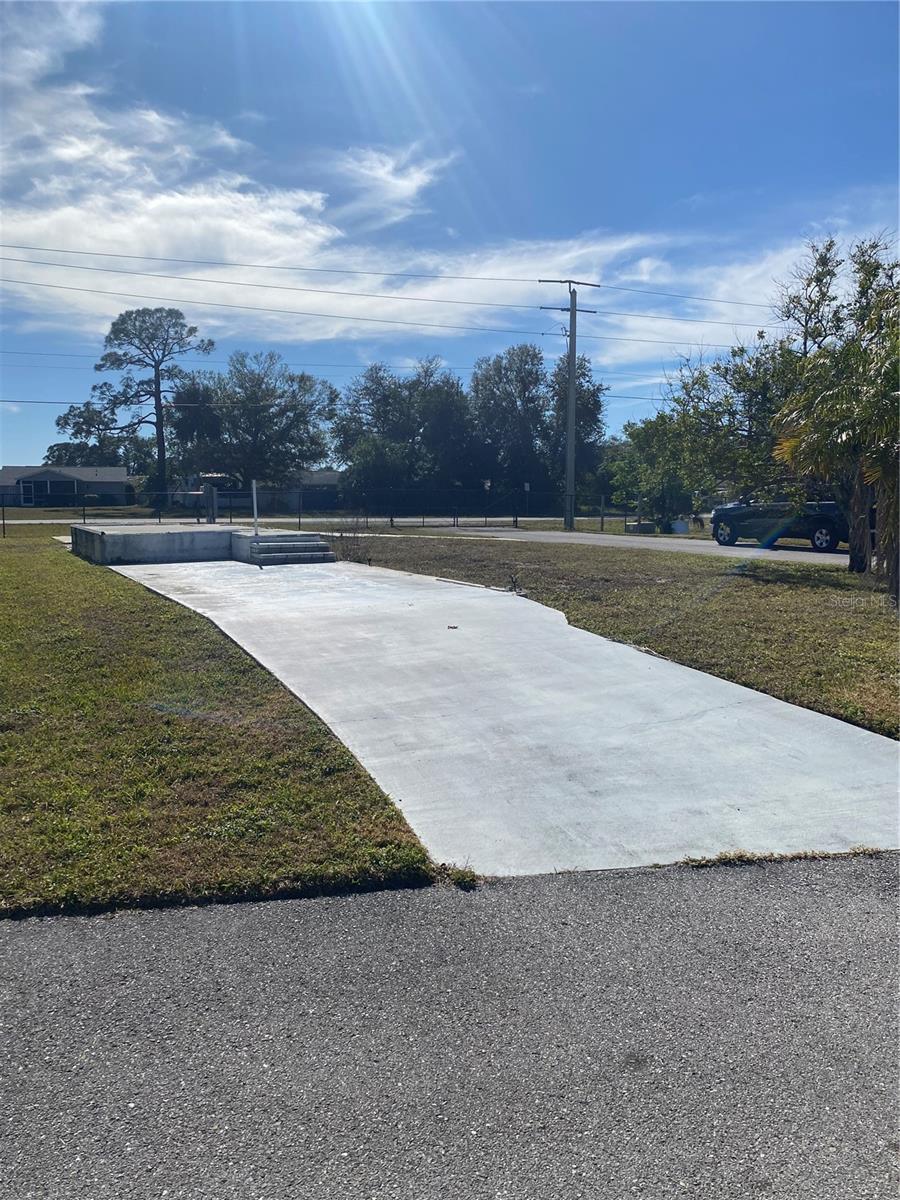 Looking for a piece of Florida paradise to call your own? This vacant mobile home lot in the 55+ community of Holiday Park, can be yours to place your new home on. It has utility connections ready for hookup. This corner lot includes two driveways and a couple of fruit trees. There is also a raised concrete pad that can be built on to add an extra room if wanted. There are plenty of recreational opportunities with the community pool, pickleball, basketball, shuffleboard and community centers. They even have a offsite bowling league! If this property interests you, give me or your favorite agent a call to schedule a time to take a look.