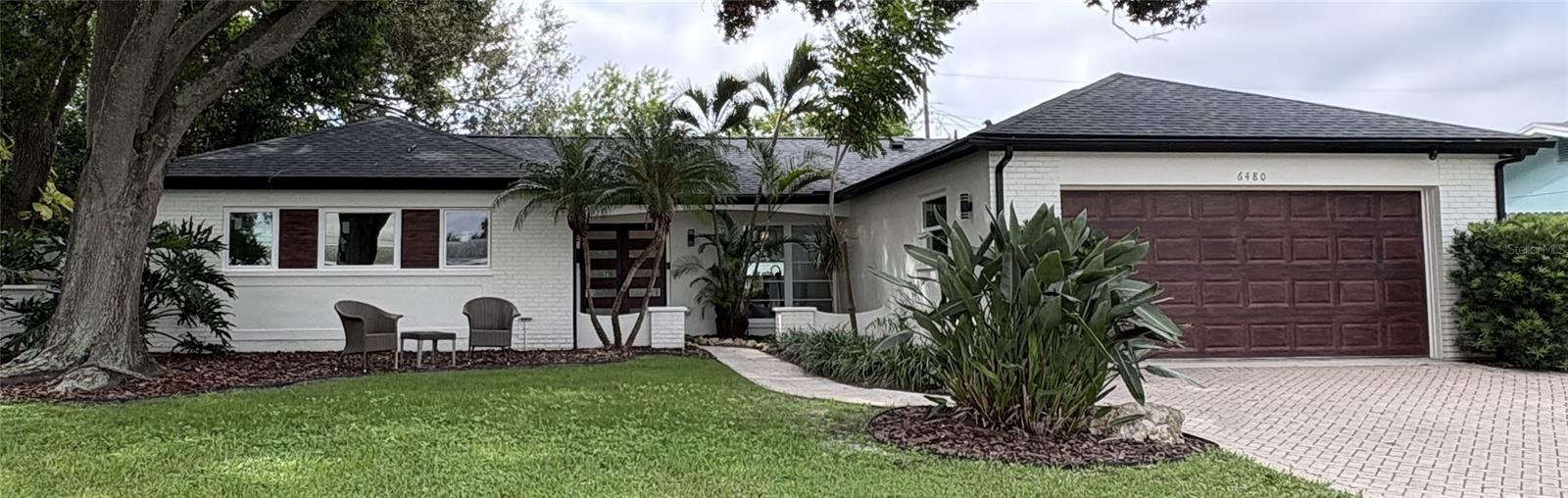 Welcome to this beautifully updated Mid-Century Modern home in the highly sought-after Holiday Park neighborhood. This 3-bedroom, 2-bath pool home with a 2-car garage has been completely renovated from top to bottom. When you enter through the new double front door you are introduced to a huge open-concept floor plan that connects the fully updated kitchen, dining, and family room as well as a separate kitchenette dining area—ideal for entertainment. The home features upgraded hurricane impact windows including a 16-foot slider as well as exterior doors. The living area includes a custom built feature wall with a new electric fireplace insert with remote control. From here, you have a massive unobstructed view of your private inground pool and extra large covered porch. The kitchen features a large island with a drawer microwave, quartz countertops and all new appliances. The 2 bathrooms are completely renovated with new showers, floors and double vanities. The primary bedroom features a sitting area, with an en-suite bath with a "zero-entry" walk in shower and an attached large walk-in closet with 2 built-in closet systems. The 2-car garage has a new hurricane garage door and a new garage door opener. Other recent updates include a new air conditioning system and ductwork, new water heater, electric panel with updated electric wiring, gutters and a new roof. And talk about convenience. The local mall is within a mile. The VA hospital is a quick 4.3 mile drive. It's only 4.6 miles to St Pete Beach and it's only 7 miles to beautiful downtown St Petersburg. All this and you're not even in a flood zone! Schedule your appointment today to see it for yourself!