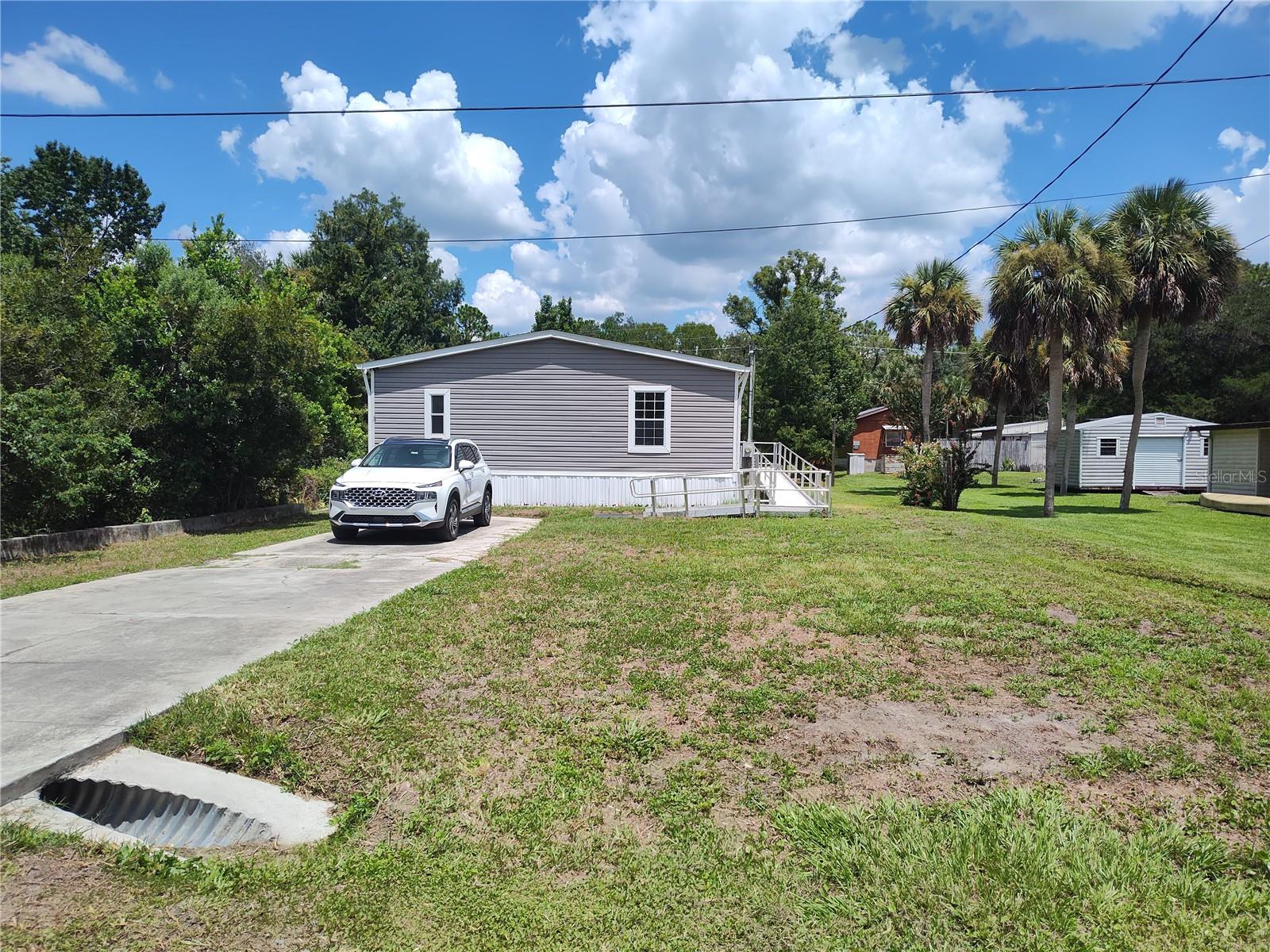 Welcome to this 2014 Live Oak mobile home in a desirable area of Homosassa. This is a 4 bedroom 2 full bath with 1,560 sf, new interior paint, new carpeting, newly installed water filtration system. The best part of this home is it sits on lot 8 and the second lot which is lot 9 has your very own pond where you can watch the wild life from the back deck or from your dining room window. It has a retention wall with an assortment of plants, some native and some planted by the previous owners. The primary bedroom has large walk in closet and there is plenty of storage in the kitchen and the extra cabinets in the laundry room. The septic has been pumped and inspected, the home has been pressure washed, concrete parking pad. Whether you are seasonal or full time residents you will enjoy all the Homosassa area has. Spectacular fishing, crabbing and scallop hunting. The Homosassa Springs Wildlife Area is just a few miles down the road along with shopping and restaurants and a hop skip and jump to Crystal River and Three Sisters Springs and the shopping and restaurants there. Don't miss out on this opportunity for a spot in Paradise.