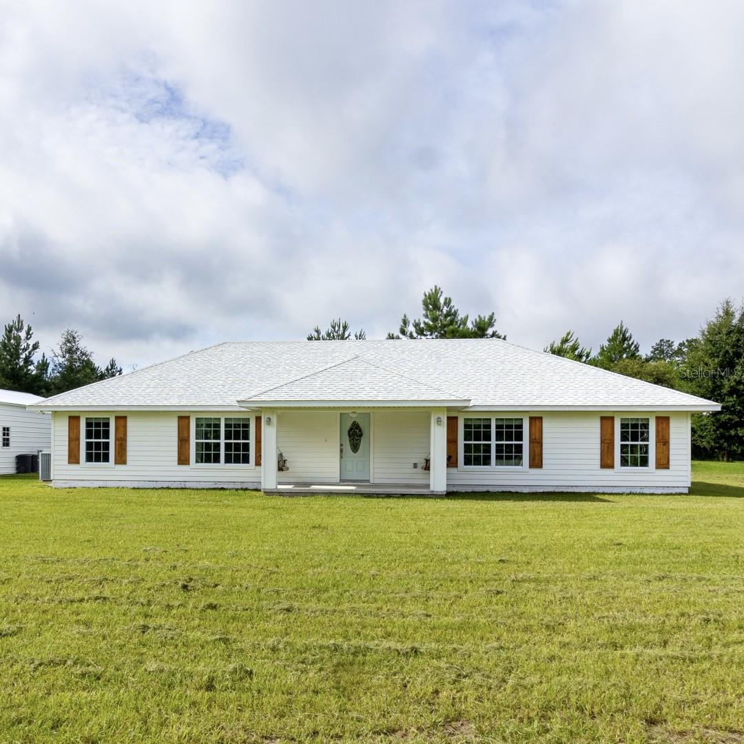 This beautiful 2 year old block home is nestled on a private,
quiet country road. It has a spacious guest apartment in the 1800 sq ft detached metal
building which is not factored into the home’s overall square footage. The home features an
open floor plan, 60 feet of shelving in the laundry room, and an extra wide bedroom hallway
which can serve as an office or play room. It comes with a whole house water filtration
system, LVP flooring, granite countertops, an in wall double oven, and generous kitchen
and dining cabinets. With an acre+ of goat-proof pasture, it's ready to fulfill your
homesteading dreams. The metal building features a finished 300 sq ft zero entry apartment
equipped with its own private entrance, full bathroom, kitchenette, mini split A/C, water
filtration system, 220 power, and its own laundry hookup in the garage. Whether you use it
as an accessory dwelling unit or mother in law suite, your guests will be perfectly
comfortable in their own space. A private country retreat and yet a short 30 minutes to UF
and 20 minutes to Wal-Mart, this home truly is the best of both worlds.