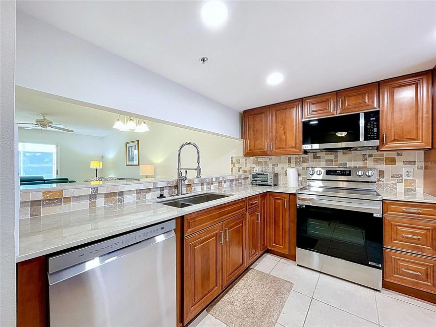 Welcome to this beautifully furnished first-floor condo located in the highly desirable 55+ Country Village community. Convenience begins right at your front door with an assigned carport just steps away, making everyday living effortless.
Inside, the home showcases a recent completely renovated kitchen. Featuring brand-new stainless steel appliances, custom wooden cabinetry, quartz countertops, recessed ceiling lighting, a spacious breakfast bar, and a pantry closet for added storage. The open floor plan creates a seamless flow through the main living areas, ideal for both daily living and entertaining.
The primary suite offers a private retreat with an ensuite bathroom and walk-in closet, while the split-bedroom layout provides excellent privacy for guests, with a full guest bath conveniently nearby. An large enclosed sunroom with washer and dryer. 
Residents of Country Village enjoy an active, resort-style lifestyle with an impressive array of amenities, including a clubhouse, heated pool and spa, shuffleboard courts, fitness facilities, pool tables, library, bingo nights, outdoor grilling areas, and a full calendar of social activities. One small pet up to 30 pounds is welcome.
Ideally situated in West Bradenton, this condo is minutes from shopping, dining, medical facilities, airports, and major highways, while also being close to some of Florida’s most sought-after destinations. Anna Maria Island, Siesta Key, and Lido Beach are all within easy reach, along with St. Armands Circle, Lakewood Ranch, and professional sports venues. 
Whether you’re looking to enjoy Gulf Coast sunsets, boating, kayaking, or simply relaxing by the pool, this move-in-ready condo delivers exceptional value, comfort, and location.