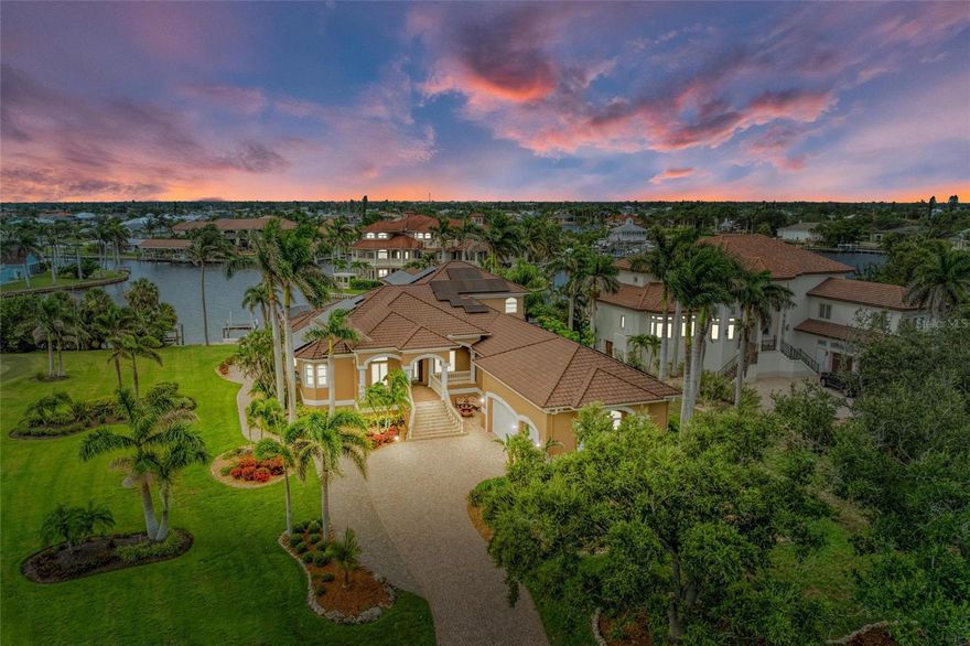 Welcome to Grassy Point Yacht Club, a rare 24-hour gated estate community on Charlotte Harbor offering private marina access, perfect for waterfront luxury living. This impeccably maintained home sits on the Elkcam Waterway, boasting panoramic harbor views and nightly sunset spectacles. The nearly 1,200-square-foot screened and covered lanai invites seamless indoor–outdoor living, with floor-to-ceiling sliding glass and glass pocket doors that open onto a gorgeous pool and spa deck. Additions include a private sunning area overlooking a neighbor’s putting green and custom Nebula lighting that sets a refined ambiance for evening entertaining.

For boating enthusiasts, the property provides a 30,000-pound boat lift with upgraded remote-controlled Gem system, stainless steel cables, pulleys, and aluminum supports, plus a full-length, deep-water concrete dock accommodating vessels up to 55 feet. A second 6,000-pound lift offers convenience for jet skis or another boat, and all 22 pilings have been freshly serviced. Dockside amenities also include dual 50 amp and 30 amp power/water stations.

In 2025, the residence received extensive luxury enhancements: the interior and exterior were freshly painted, the primary suite received elegant wide-plank porcelain tile flooring, and the home was outfitted with ten high-end ceiling fans, recessed LED lighting, and premium linear HVAC vents. The kitchen has been transformed with designer quartz countertops, backsplash, a new refrigerator, dishwasher, wine/beverage cooler, plus under- and over-cabinet lighting. Both covered porches have tongue-and-groove wood ceilings, and the landscape was fully renovated with new irrigation and an underground 250-gallon propane tank powering the outdoor kitchen and lanai fireplace.

Built to stand the test of time, the home features a 50-year Boral stone-coated steel roof, a solar system generating 110% of its power needs, two high-efficiency water heaters, whole-house filtration, a Generac propane generator, and three high-efficiency HVAC systems. With hurricane-rated windows, storm coverings, and four ensuite bedrooms, including primary suites on both levels, plus custom plantation shutters throughout, every detail balances comfort and resilience.

The oversized garage adds room for three to six vehicles, complete with epoxy flooring, hurricane-rated doors, built-in storage, and an EV charger, while the paver driveway and walkways lead to an additional RV hookup and accentuate the residence’s polished curb appeal. This property is not just a home, it’s a waterfront sanctuary designed for entertaining, relaxation, and luxurious everyday living. Schedule a private showing to experience its full splendor. 
See attached feature sheet for full list of upgrades. SELLER FINANCING AVAILABLE! BE SURE TO CLICK THE FULL VIRTUAL TOUR LINKS FOR DETAILS!