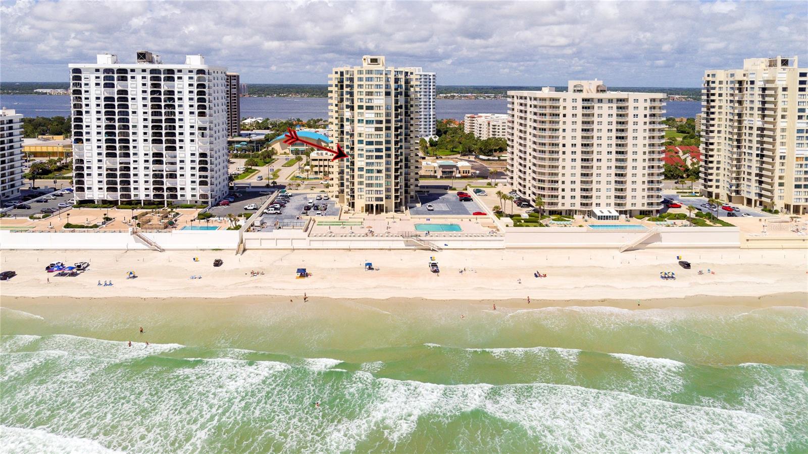Located on the 7th floor with the much-desired southeast direct ocean views, this condo is ideally located for convenience and the best of oceanfront living. Enjoy the ocean breezes from the direct ocean-front balcony, watch a shuttle launch or spy on beachgoers below. Light and bright, the big windows maximize the joy of sunrises and ocean and river views. The kitchen, with corian counters and white cabinets, is open to the dining room. The two bedrooms are generous, with an ensuite primary bedroom and a second bath with easy access for guests and the second bedroom. Convenient! Just one block to the Publix Shopping Center and Walgreens, across from an executive golf course, and Daytona Beach Shores Community Center with lots of available activities. Oceans Five is undergoing a multi year renovation including new hurricane glass in common areas, lobby updates, elevator updates, seawall and beach access updates, pool deck updates and life safety improvements to prepare this property for many years to come. On site management provides another level of security for full and part time residents. Electric blinds in the living and primary bedroom. Electric roll down shutters on all but the south facing window. This condo offers a perfect combination of location and ocean front living at an affordable price!