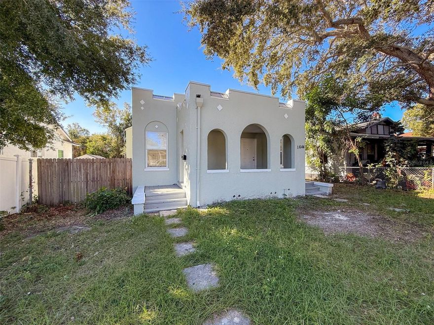 Step into this charming Spanish Mediterranean-style 3-bedroom home near downtown St. Petersburg where timeless architecture meets thoughtful updates and solid income potential. With fresh interior and exterior paint, this move-in-ready residence blends historic character with a functional layout designed for modern living. A spacious covered front porch welcomes you, offering the perfect spot to relax or boost curb appeal with cozy outdoor seating. Inside, you’ll find high ceilings, durable tile flooring, and graceful archways that create an open, airy feel. The living room features a decorative fireplace and flows effortlessly into the dining area and kitchen, which offers convenient side-door access to the fenced backyard. Three generous bedrooms share a large hall bath, along with a roomy hallway that includes built-in storage and a dedicated indoor laundry area. The fully fenced backyard with alley access provides ample space for entertaining, pets, or potential parking with fence modifications and the addition of a driveway. Recent updates include a new roof (2023) and updated windows (2014) for added peace of mind. Ideally located just minutes from vibrant Downtown St. Petersburg, this property is perfect for a first-time homebuyer or investor seeking strong rental income and long-term value.