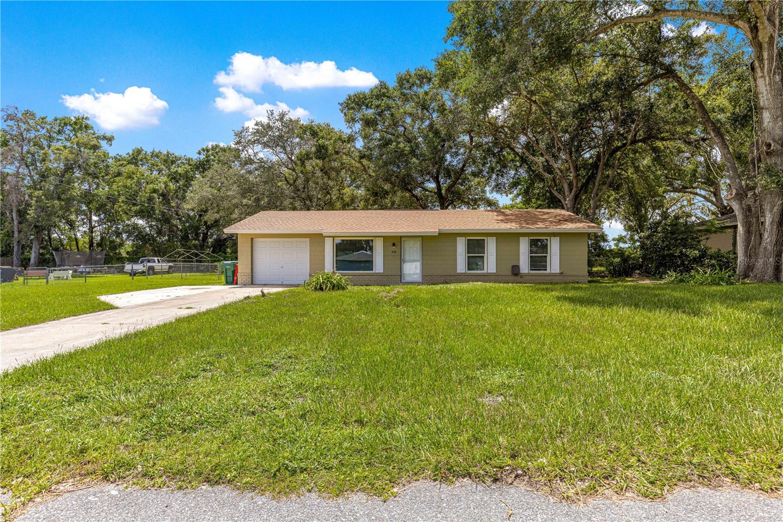 Welcome to 998 Hibiscus Street, Lady Lake, a beautifully remodeled home that is move-in ready. A brand new roof was installed in 8/2025 A new Goodman Air conditioning system was installed 7/2025. All the windows were replaced in 2024. All Kitchen appliances were replaced in 2025. When you walk thru the freshly painted home you will notice that all four fans have been replaced with light kits. The driveway has been widened to accommodate two cars for off street parking. The rear yard is a quarter of an acre and all fenced in for your pets to run around and enjoy the shade of the mature trees. As you are enjoying the patio and the backyard you will notice the quiet peacefulness of not having any rear neighbors under the large shade trees. A Klimaire mini split A/C unit has been added to the garage so could be an extra room if needed or a fourth bedroom. This home is conveniently located close to The Villages and all the shopping and entertainment for you to enjoy. This is a great home in a great location ready for a new owner. Call for a private showing before its gone.