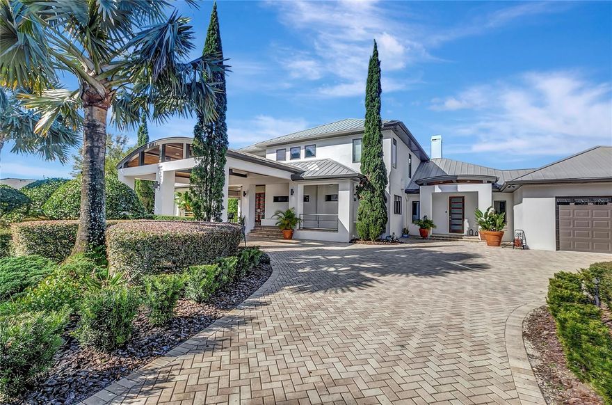 Nestled within the highly sought after Sanctuary on Livingston, this magnificent luxury estate commands attention with its lavish 1.5-acre manicured grounds and alluring contemporary design.  A circular paved driveway leads to a distinctive porte-cochère with elegant tongue and groove ceilings, setting the stage for this modern architectural masterpiece. The grand entrance opens to an idyllic living space, anchored by a dramatic metal and wood floating staircase, enhancing its modern allure. Hardwood floors gleam throughout, complemented by stacked stone accents, marrying earthy elements with contemporary design. The home boasts 22-foot ceilings and floor-to-ceiling windows, bathing its interior in natural light, with stunning views of the pool and tropically landscaped grounds throughout the home.  Breathtaking kitchen is a chef’s delight, equipped with professional-grade Thermador, Sub-Zero, and Miele appliances, including coffee service and wine refrigerator. A massive island, luxurious wooden cabinetry, and a butler’s pantry with extensive storage and additional refrigerator underscore the kitchen’s elegance. The light-filled family room, with its stone fireplace, opens to a resort-like pool, spa, and lanai, perfect for entertaining. The first floor features a luxurious guest suite  (or second master suite), an additional bedroom, and a versatile bonus room. Upstairs, the opulent master suite offers a spa-like bath with a unique island of cabinets and a glass shower with 10 heads, alongside a vast closet with custom built-ins. Two more bedrooms share a Jack and Jill bath. Outdoor living is unparalleled, with an exquisite kitchen, multiple seating areas, and lush landscaping.  An outdoor cabana off the pool is the perfect setting for entertaining.  Fully fenced yard overlooking a sparkling pond.  Outside you'll appreciate an attached 2 car garage and an additional detached garage. Located in a boutique gated community of custom-built luxury homes on lots over an acre, this estate offers privacy and serenity while being only minutes from Tampa International Airport, major highways, Downtown Tampa, shopping, restaurants, medical facilities, and entertainment. This estate is not just a home; it’s a lifestyle you'll relish, and the perect setting to create memories that will last a lifetime.