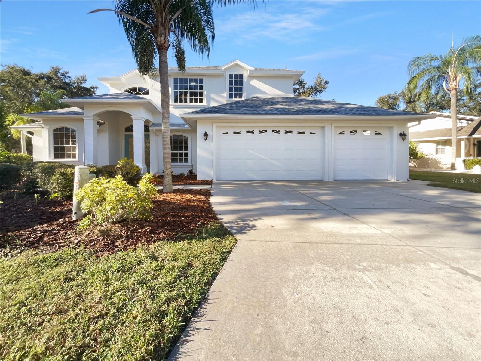 One or more photo(s) has been virtually staged. Timeless remodel in a quiet Lakewood Ranch–area enclave. Set on a low-traffic street lined with mature palms, this light-filled two-story home blends classic architecture with a fresh, move-in ready renovation. A wide three-car garage and a welcoming front porch lead to a dramatic double-door entry and soaring foyer with custom ironwork—an elegant first impression for everyday living or entertaining. Inside, flexible formal and casual spaces make it easy to spread out. The refreshed kitchen anchors the home with quartz counters, an oversized island, stainless appliances, abundant storage, and under-cabinet lighting. It opens to a comfortable room with a fireplace and built-ins—perfect for movie nights and gatherings. Thoughtful touches continue throughout: crown molding, tray ceilings, wainscoting, updated lighting, and new interior finishes that feel cohesive and calm. Retreat to a spacious private suite with a spa-style bath featuring a freestanding soaking tub, frameless glass shower, dual vanities, and serene treetop views. Secondary bedrooms are generously sized with an updated bath offering double sinks. A first-floor flex room and multiple living/dining areas provide options for an office, play space, or guest quarters as your needs evolve. Out back, a screened lanai looks onto lush landscaping—ideal for morning coffee or weekend barbecues—with plenty of yard space to play. A smart alternative to new construction, this home offers more space, character, and an exceptional location—ready for your next chapter. Included 100-Day Home Warranty with buyer activation
