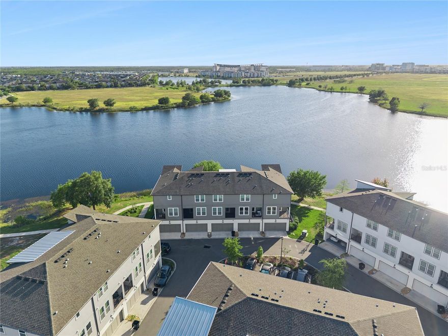 Welcome to 12436 Koshiba Alley, a beautifully maintained CORNER UNIT, 3 STORY TOWNHOME in the heart of Laureate Park, offering 2,167 square feet, 3 bedrooms, 3.5 bathrooms, a 2 car garage, and GORGEOUS LAKE VIEWS. With its BRIGHT, MODERN FEEL, flexible layout, private setting, and unbeatable location, this is the kind of townhome that stands out from the rest. What makes Koshiba Alley so special is that it offers something many townhomes cannot, a sense of PRIVACY, OPENNESS, AND PEACEFUL WATER VIEWS, while still placing you right in the center of everything that makes Laureate Park so desirable. From the moment you arrive, you feel the difference. As a corner unit, the home is filled with natural light and enjoys a more open, airy feel than surrounding properties. Inside, the layout is both functional and inviting, designed to fit the way people live today. The first floor features a private bedroom with a full bath, ideal for guests, multigenerational living, or a quiet home office. Upstairs, the main living level is open and full of light, creating an effortless flow for both everyday living and entertaining. The kitchen is beautifully appointed with white cabinetry, stainless steel appliances, a built in wall oven and microwave, sleek vent hood, pantry, and a large center island that anchors the space. Just off the living area, the COVERED BALCONY becomes an extension of the home, offering the perfect place to enjoy your morning coffee, unwind in the evening, and take in the SUNSET AND WATER VIEWS. On the top floor, the spacious primary suite offers a relaxing retreat with generous closet space and a bright en suite bath, while the additional bedroom and UPSTAIRS LAUNDRY add comfort and convenience to the home’s thoughtful design. Beyond the interior, this location is what truly elevates the lifestyle. Here, you get the rare combination of WATERFRONT SERENITY AND EVERYDAY CONVENIENCE. Enjoy feeling tucked away in your own peaceful pocket of the neighborhood, while being just moments from everything Laureate Park is known for. Located just TWO BLOCKS FROM CANVAS, THE FITNESS CENTER, BASKETBALL COURT, AND THREE COMMUNITY POOLS, this home offers easy access to the neighborhood’s most loved amenities, along with nearby parks, playgrounds, and walking trails. Its position within the community also allows for EASY ACCESS IN AND OUT of the neighborhood, making day to day living even more convenient. For buyers comparing townhomes in Lake Nona, 12436 Koshiba Alley offers more than just square footage, it offers a lifestyle. LAKE VIEWS, SUNSET SKIES, A BRIGHT CORNER UNIT SETTING, ADDED PRIVACY, LOW MAINTENANCE LIVING, AND WALKABILITY TO TOP AMENITIES all come together to make this home a standout opportunity in one of Lake Nona’s most sought after communities.