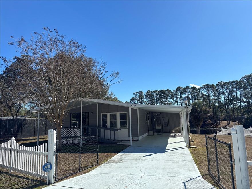 Enjoy peaceful and relaxing tranquil views right from your own backyard! Updated 2/2 Waterfront Doublewide on a picturesque pond with wildlife and fish galore located in the heart of the Ocala National Forest. Only a half mile away from the Lake Bryant Fish Camp which features a free public boat slip/ramp area into beautiful 800-acre Lake Bryant! Completely fenced in .25 acre with partial privacy fence and vinyl fencing along with separate area fenced in for animals to roam. Landscaped beautifully, custom stucco under skirting around the outside of home, firepit, sea wall and metal roof (2008). Paved street neighborhood on a cul-de-sac leading to a front gate entrance with a 2-car paved driveway to an attached massive 40 x 12 two Car carport. 24 x 10 front porch with handicap accessible ramp entrance. 10 x 8 attached storage room with laundry hook ups, sink, and workshop area. Enjoy the beautiful pond views from the roomie 24 x 10 back screened porch. Seller, has done many updates which include: new hot water heater in 2025, Outside of the whole home was completely painted in 2024, New AC unit in 2018 along with being updated/serviced in 2023, All new double pane windows and blinds throughout in 2020, New metal roof in 2008, New privacy fence in 2021, complete new shower in 2021 in the guest bathroom, New plumbing in 2021, Updated subflooring in 2017, New screening on back porch in 2021, handicap accessible handles in bathrooms and showers in 2021. Inside features a traditional separated kitchen with lots of cabinet space, eat in kitchen bar, dining area/room with storage/shelving, spacious living room, spacious walk-in closets in both bedrooms. Enjoy the pond views right from your master bedroom. This home is very well taken care of inside and out and furnishings in the pictures are included, make an offer today! Home is located in the Ocala National Forest which affords you almost a ½ million acres of Forest to roam, 600 lakes, 2 rivers, Juniper Springs, Silver Glen Springs, Salt Springs, Swimming, Skiing, Big BASS Fishing, Boating, Camping, Hiking, Horseback riding and some of the best ATV riding anywhere. Daytona Beach is just 1 hour away. Let the fun begin! You need it!