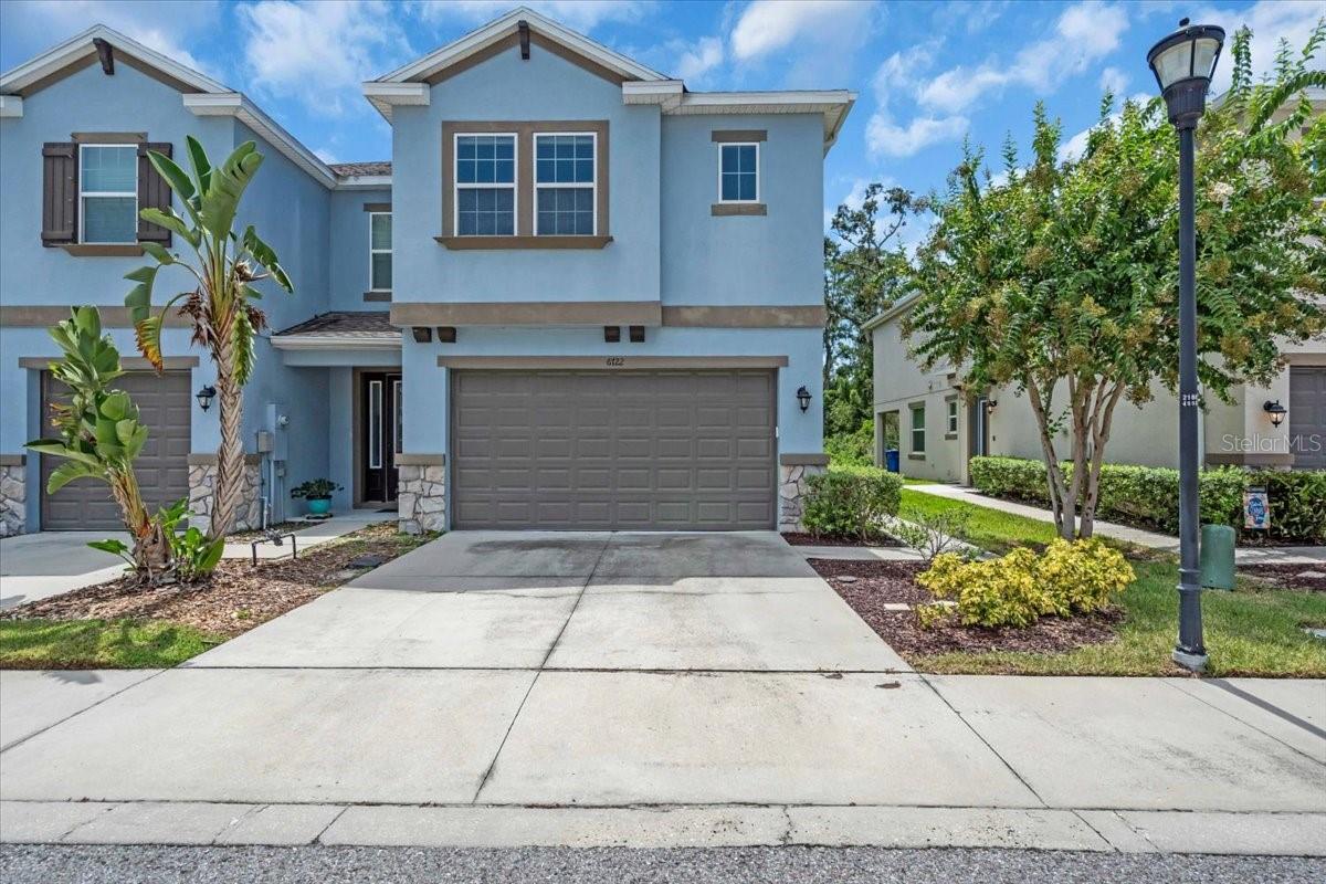 Experience modern living at its finest in this beautifully appointed corner unit Townhome, showcasing a spacious open layout and located in a resort-style community with a sparkling pool and scenic green spaces perfect for relaxing walks. This 3 bedroom, 2 bath home with a versatile bonus loft is designed to impress with elegant wood flooring, upgraded kitchen cabinetry, and Hunter Douglas custom motorized blinds on every window. Enjoy a sleek, clutter-free look with hidden TV cables, and stay comfortable year-round with an insulated garage door enhancing energy efficiency, reducing noise, and protecting stored items from the elements. A built-in EV charger, automatic exterior lighting, and countless smart-home touches add unmatched convenience. Seller is offering $5,000 toward closing costs, a rare opportunity for buyers. This move-in-ready gem combines luxury, functionality, and location schedule your private tour today!
