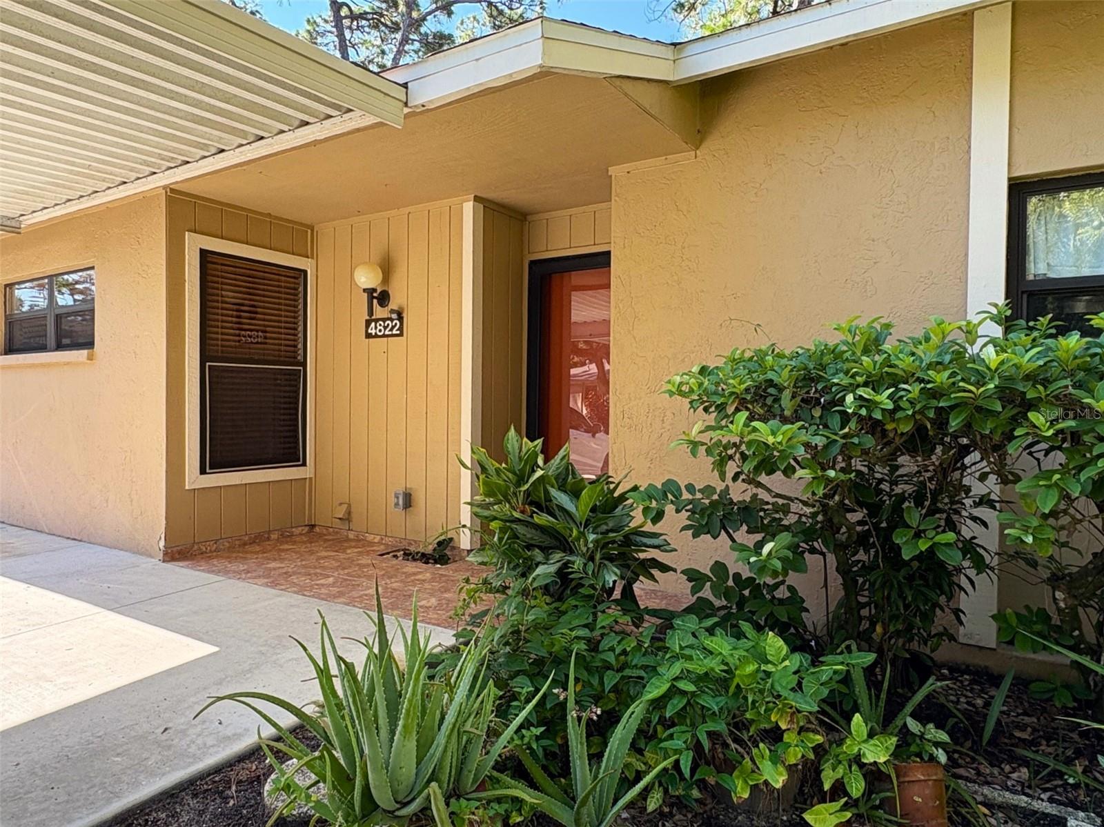 Welcome to this charming remodeled one-story villa-style condominium, offering a comfortable and inviting space to call home. With 2 bedrooms and 2 baths and a screened lanai in view of towering palms and lush tropical plants. The bright kitchen boasts granite countertops, stainless steel appliances, and is open to the dining and living areas—perfect for casual living and entertaining. The primary bedroom includes a contemporary barn door leading to a large ensuite with a customized walk-in closet, dual sinks with storage drawers underneath, a floor to ceiling cabinet, and in-ceiling rain-shower. The guest bedroom also features a customized walk-in closet and remodeled guest bath. Updates include a newer hot water tank and AC. There is one covered parking space and a second parking space in front of the residence. Village Gardens is a pet-friendly community, allowing 2 pets weighing up to 40 lbs each. Amenities include one tennis/pickleball court, two shuffleboard courts, a newly surfaced heated pool, and a poolside ramada with two gas grills plus tables and chairs; the clubhouse has a kitchen, library, and on-site manager office. There are two parking spaces across from the pool that are designated for car washing, a drive-through recycle area with air hose for car tires. Located just 10 minutes from downtown Sarasota, UTC Mall, I-75, and the airport, this home offers both convenience and potential. Don’t miss your chance to make this lovely condominium yours!