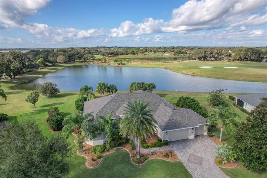 Are you are looking for that extraordinary Villages home to make your own?  This property is 3600+ sq. ft., block and stucco, 4 bedroom,(one used as a study), 3 bath, 3 car garage home and has a myriad of special features inside and outside of the house. 
It has a SOUGHT-AFTER LOCATION in Bridgeport at Lake Sumter, a Village of premier homes adjacent to the town of Lake Sumter Landing. It boosts WATER VIEWS - simply spectacular 180 degree water views, with phenomenal bird and water-bird watching, sporting hundred year old oaks as a backdrop.  All this is viewed from your OVERSIZED ONE-HALF+ ACRE LOT with plenty of space for a pool, if desired.   And the GOLF VIEW - from your lanai or family room you can watch the golf action on Arnold Palmer Championship Riley Grove Course, Hole 1, all the way from tee box to the green. 
The HOUSE itself is truly stately and oh so livable and lovable. The home has been dramatically changed and now includes a redesigned GOURMET KITCHEN with a center island, light color cabinets, and with appliances that are a joy to view and to use.  These include a 48 inch professional Sub-Zero refrigerator with a window, European Miele double oven (both are convection and standard), Miele 3-tray dishwasher, microwave drawer, and a center island with Miele 5 burner induction cooktop -(faster and cleaner than gas ), and a Miele range hood that is vented outside.
All three BATHS have been updated. The two guest baths have new rectangular Toto sinks, Rohl brushed nickel faucets and granite vanity tops. The owner's bath has been totally revamped and is a spa-like classic bath all done in various sizes and shapes of CARRARA MARBLE.  It has a gorgeous chandelier that when viewed in either bath mirror goes on to infinity. It also features locking jewelry drawers and a relaxing seated vanity area for makeup and hair.
The owner's closet is custom designed and has new recessed lighting and an antique chandelier.
The FLOORS throughout the house, except baths and laundry, are all random width, hand-scraped Hickory engineered hardwood. MOLDINGS include crown molding, window moldings, and wainscoting in the kitchen eating and barstool areas.  WINDOW COVERINGS through the house are beautiful plantation shutters on the windows or Hunter-Douglas Silhouette blinds. The lanai has electric sunshades and bronze trimmed frameless screens. 
The LAUNDRY room has a commercial oversized Miele washer and dryer, new faucet and square sink, granite counter and lots of storage cabinets.
The spacious 3 CAR GARAGE has plenty of custom storage cabinets and has epoxied floors.  The attic above the garage has added insulation.
The DRIVEWAY and front walkway have newly installed (2022) thick pavers patterned with three different size bricks.  
Other important updates include two new water heaters in 2020 - one electric and one gas, and a new roof also in 2020.
For peace of mind, a Broward one year home warranty is included.
This home has many unique qualities, including its convenient location, and its beautiful natural setting. It is looking for the new owner who will enjoy and appreciate its beauty, luxury, and space.