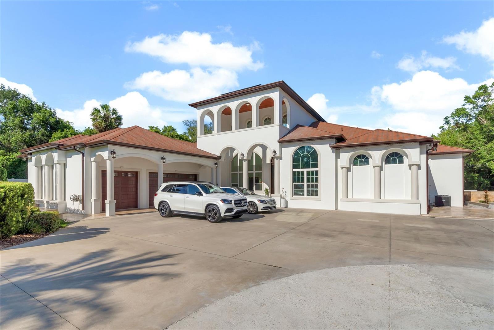 One or more photo(s) has been virtually staged. WELCOME HOME to this immaculate and impressive gated 4.86 Acre Estate. As you drive up the first acre of land to your home, you’ll notice the lamp posts evenly spread, to light up your path at night. The property is broken up into two parcels, the front parcel is 1.94 acres, while the home sits on a impressive 2.92 acres. No rear neighbors & you can live off the oasis of your land! The property is brilliantly designed with custom architecture, a DreamWorks construction, and features every Luxury complimentary to your lifestyle. You are greeted with a magnificent, well-manicured lawn, long private driveway, new landscaping throughout the property that highlights your private putt golf course, a volleyball court, playground, and large outdoor entertainment area. The craftsmanship of the 14ft custom French doors & 20 ft ceilings set the tone for the grandeur of what this one-of-a-kind luxury home offers. The home is adorned with freshly painted exterior & interior (over $50k value), marble floors, coffered ceiling and brand new breathtaking Italian crystal Chandeliers (over 80k value). Once inside you are greeted with the natural lighting that illuminates the open concept floor plan from the 12ft glass windows that are consistent throughout the entirety of this oasis of a dream home with new custom window treatments (over $10k value). The kitchen boasts custom cabinetry with elegant brass/stainless details (over 10k value), large walk-in pantry, luxurious Thermador stainless steel appliances featuring a double oven, gas stove top, beautiful granite, a very large island, intricate moldings, tray ceilings, all add depth and warmth to every room featured in this masterpiece. The sanctuary that is called the Master measures 30x35, double French glass doors leading to the 1,400 sq. ft. patio which offers your own personal luxurious retreat. Your custom master bath boasts double vanities, his and her walk-in waterfall shower and his and her walk-in closets, with a private space for an office overlooking your pool jetted pool & infinity jacuzzi. This home just keeps on giving as it offers a 400 sq. ft. bonus loft perfect for a game room or custom movie theater. The loft can easily be converted to a balcony overlooking your beautiful oasis. Complementing the interior, the outdoor space offers resort style living with a magnificent BRAND-NEW pool, features travertine tile, a LED lighted pool cage, rich wood planked ceilings, multiple seated areas for entertaining, kitchen, and private pool bath. The property is also fitted with 55 solar panels that essentially eliminates your entire electric bill. The three-car massive garage is perfect to house all your toys and with a driveway that can park another 50+ cars comfortably for when you entertain. This beauty keeps on giving as there are already approved plans for a 4-bedroom 3 bath guest home on the first 1.94 acres of the property, if you wish to continue this oasis. The 6th bath is located in the shed on the first acre of land by the outside entertainment space. This home has recent upgrades over $400k in value to complete the luxury finishes that make this house a home. Conveniently located between Tampa & Orlando. This is your opportunity to own a piece of heaven on earth. SCHEDULE YOUR PRIVATE TOUR NOW!