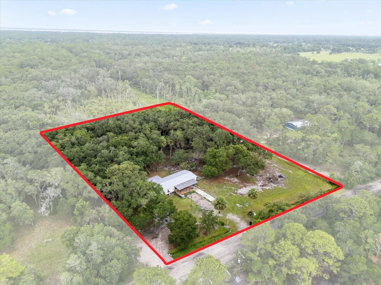 The perfect land in Geneva to realize your vision is now available! Encompassing over 5 acres, you can build your dream home or bring new life to the existing 3 bedroom, 2.5 bathroom manufactured home with renovations as low as $25K. Manufactured home has electric, plumbing, metal roof with a 45 year warranty. This exceptional property in a rural Geneva setting offers a unique combination of cleared land, natural privacy provided by large, mature oaks in the backyard, and the convenience of established infrastructure: electric, internet, a new well, and septic systems are already in place for immediate use. A pole barn, currently undergoing renovation, offers valuable covered space. Notably, this property remained high and dry throughout Hurricane Ian. Whether you desire a tranquil nature escape, or a peaceful atmosphere, this property presents incredible potential. The land is being cleared of all remaining wood, including the front and back porches of the current manufactured home so that you are ready to either renovate or set plans in motion to build your dream home. Outlets and electricity available in shed.