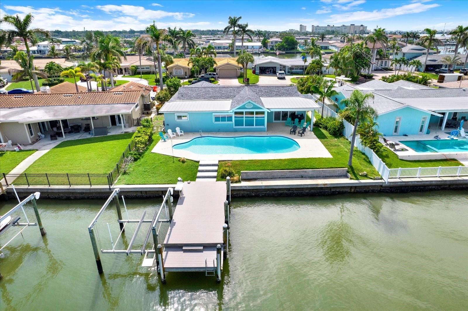 SOAK UP THE PINNACLE OF WATERFRONT LIVING FROM THIS BEAUTIFULLY REMODELED 3BR/2BA HOME IN THE COVETED OAKHURST SHORES COMMUNITY OF SEMINOLE! Located in Unincorporated Pinellas County, this home is the perfect primary residence or short-term rental! Offering 1,968 Sq Ft of dazzling living space, this home boasts block construction, OVER $60K IN ELECTRIC HURRICANE SHUTTERS, A NEW ROOF IN 2023, NEW WINDOWS AND DOORS THROUGHOUT, BRAND NEW HVAC SYSTEM and so much more! Situated on 77 feet of prime water frontage on a wide canal, the Intracoastal Waterway is just seconds away and access to the Gulf through John’s Pass is minutes by boat. Soak up tons of natural sunlight and magnificent views of the water from the living room, breakfast nook, and expertly updated kitchen- featuring granite counters, white cabinetry, and BRAND-NEW APPLIANCES. There is a formal dining area for entertaining, as well as a spacious, covered patio area outside, for al fresco dining overlooking the waterfront and pool. The dreamy primary suite features a beautifully remodeled en-suite bath with a glass shower, dual sink vanity and new light fixtures. The other 2 spacious bedrooms have brand new luxury vinyl flooring and share a remodeled hall bath with a tub/shower combo. The waterfront pool features a new filter/pump and the NEWER COMPOSITE DOCK AND BRAND NEW 10,000LB BOAT LIFT are ready to go for the next owner! There’s a 2-car garage and no shortage of parking space on the massive CIRCULAR PAVER DRIVEWAY! Oakhurst Shores is biking distance to Madeira Beach, Seminole City Center, and just a quick drive to top-rated schools. This neighborhood has never flooded until Hurricane Helene, making it one of Pinellas County’s most desirable waterfront locations on the mainland. For boaters, there are NO FIXED BRIDGES TO CONTEND WITH and several restaurants that are a short boat ride away. This home is truly in move-in ready condition! Make an appointment to see it today!