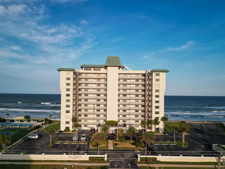 Panoramic oceanfront living awaits in this beautifully positioned three bedroom, three bath direct oceanfront condo. The second-floor location offers sweeping ocean and beach views—not just the horizon—capturing endless coastline scenery stretching north along New Smyrna Beach. Enjoy the convenience of easy access via stairs or elevator. Located in the sought-after Southwind condominium, residents enjoy luxury amenities including tennis and pickleball courts, a heated oceanfront pool, and a top-floor clubhouse featuring a kitchen, fireplace, and billiards perfect for entertaining and available for private gatherings. All amenities are situated on the quiet, no-drive portion of the beach. The unit may be sold turnkey, if desired. Interior features include tile flooring throughout, impact windows with storm shutters, a new hot water heater, and an in-unit washer and dryer. The primary suite and west guest bedroom both offer ensuite baths, while a centrally located third bath serves guests and the third bedroom. With owner usage variations, annual rental income has reached up to $83,000 after management fees, making this an exceptional opportunity for both personal enjoyment and investment.