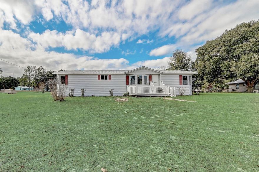 One or more photo(s) has been virtually staged. Set on a full acre just minutes from the heart of Gainesville, this well maintained manufactured home offers space, comfort, and convenience in one inviting package. With 1,911 square feet, three bedrooms, and two bathrooms, the layout is designed to feel open while still offering privacy where it counts. As you step inside, vaulted ceilings immediately draw your eye and enhance the bright, open living area. The living room flows easily into the dining space and kitchen, making everyday living and entertaining feel effortless. The kitchen is generously sized and features a center island along with abundant cabinet and counter space, ideal for cooking, hosting, or casual meals. The primary bedroom is spacious and tucked away for added privacy. It includes an en suite bathroom with dual sinks and a separate soaking tub and shower. A split bedroom floor plan places the additional bedrooms on the opposite side of the home, offering flexibility for guests, a home office, or other needs. Outside, the oversized lot provides endless possibilities, with the added benefit of access from two different roads thanks to the expansive acreage. Enjoy the open space, a convenient storage shed, and plenty of room to create your ideal outdoor setup. Located just minutes from downtown Gainesville, the University of Florida, grocery stores, dining, and shopping, this property combines peaceful acreage living with easy access to everything the city has to offer. Mortgage savings may be available for buyers of this listing.