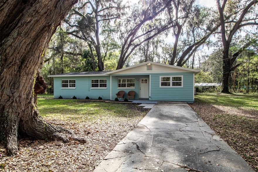 Located just minutes from Celebration Pointe and Archer Road, this move-in ready concrete block home sits on a beautiful half-acre lot under a mature tree canopy with no HOA—an increasingly hard combination to find in southwest Gainesville, especially at this price point. Set in a quiet and private setting, this 2-bedroom, 2-bathroom property offers over 1,200 square feet of comfortable living space with an open concept living area and a flexible layout that includes a bonus room that could easily serve as a third bedroom, home office, game room, or additional living space. Major updates have already been completed, including a new roof in 2023, a newer electrical panel, HVAC and water heater replaced in 2019, newer windows, fresh exterior paint, along with luxury vinyl plank flooring and wood blinds throughout, making this home truly turn-key—just bring your clothes and furniture. The updated primary suite features a walk-in closet and renovated ensuite bathroom with a dual-sink marble vanity and stand-up shower. The kitchen offers pantry storage and newer appliances, and the home also includes a dedicated laundry area. Serviced by well and septic with a water filtration system and softener, the home benefits from lower utility costs. Outside, the spacious lot provides plenty of room to enjoy the outdoors with a fire pit area, chain link and wire fencing with the option to add a gate, and ample space for a storage shed, a future pool or addition, RV or boat parking, gardening, or pets. Conveniently located near shopping, dining, UF, Shands, and I-75, this property offers a rare combination of space, updates, and location—making it an excellent opportunity for a first-time buyer, investment property, or anyone looking for extra room close to town.