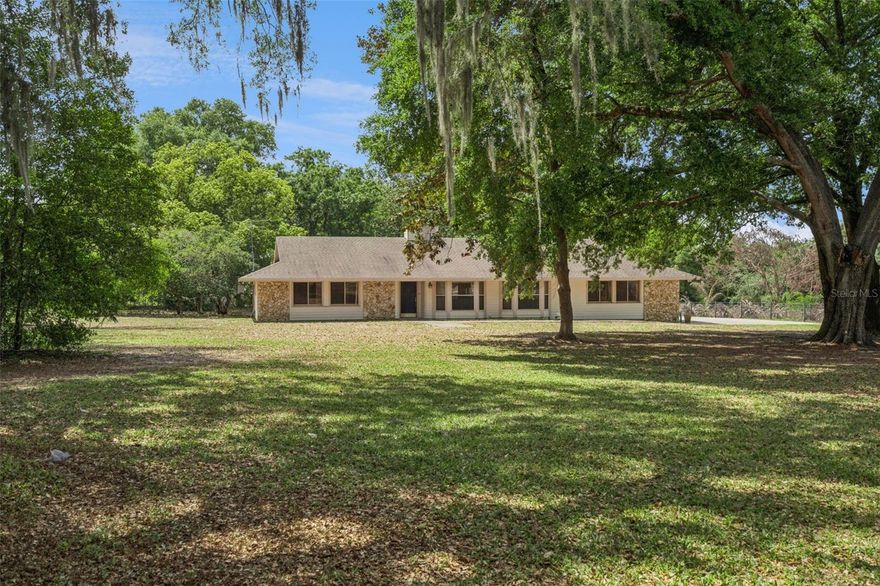 Discover a rare opportunity to own a private estate property in one of West Orange County’s most desirable corridors. Situated in Oakland, this 2.55-acre parcel offers space, privacy, and future potential just minutes from the conveniences of West Colonial Drive, Florida Turnpike (Exit 275), Clermont, and the vibrant districts of Oakland and Downtown Winter Garden. Properties like this are increasingly difficult to find. The home sits in an unincorporated area, giving flexibility and freedom while still being close to everything that makes this area so special. Walk or bike to the West Orange Trail, enjoy easy access to local parks, and connect quickly to shopping, dining, and major commuter routes. The residence offers approximately 2,700 square feet of living space and has been thoughtfully maintained in its original 1983 character, making it ideal for buyers seeking land, privacy, and the opportunity to personalize or modernize over time. Inside, you’ll find an open floor plan with soaring vaulted ceilings and large picture windows that fill the home with natural light. A dramatic floor to ceiling stone fireplace anchors the main living area and creates a warm focal point for gatherings or quiet evenings at home. The kitchen is spacious and functional, featuring abundant cabinetry, a large center island, built in appliances, and generous room for entertaining and everyday living. A large enclosed sunroom extends the living space and offers endless possibilities for a game room, fitness studio, home office, or year round relaxation overlooking the backyard. The home includes four generously sized bedrooms and two full bathrooms, all preserving their original charm and offering a strong foundation for updates, renovation, or a curated vintage aesthetic. Step outside and the true value of this property becomes clear. The 2.55 acres provide room for gardens, animals, workshops, RV and boat storage, or the creation of a private retreat. A detached casita adds flexibility for guests, extended family, a home office, or potential future income use. The property operates on a private well and septic system, offering independence, lower utility costs, and a rural lifestyle feel without sacrificing proximity to major roads, downtown Winter Garden, and the growing Oakland corridor. A unique blend of land, location, and opportunity this is a property where you can create, expand, and invest in a lifestyle that is increasingly rare in Central Florida.