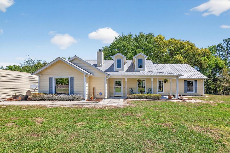 Escape to your own private lakefront countryside retreat with this picturesque pond-front property set on 8± acres, offering incredible equestrian potential and peaceful, open space. This charming 5-bedroom, 2.5-bath ranch-style home spans 2,381 square feet and is perfectly positioned with a generous setback, creating a serene sense of arrival through the expansive front yard. Designed for both comfort and functionality, the property features two cross-fenced pastures shaded by mature trees, a garden area, a large parking pad, and a 20x20 metal carport with a workshop. A paver walkway leads to the inviting front porch—an ideal spot to unwind with morning coffee or enjoy a refreshing drink on a warm afternoon. Inside, vaulted ceilings and low-maintenance tile flooring enhance the bright, open-concept layout. The living room centers around a cozy wood-burning fireplace and flows seamlessly into the kitchen and dining areas, creating the perfect space for everyday living and entertaining. The kitchen is well-equipped with abundant wood cabinetry, stainless-steel appliances—including a French-door refrigerator—and a convenient breakfast bar for casual gatherings. Double French doors open to a spacious Florida room, where panoramic windows invite in natural light, backyard views, and gentle breezes. The primary suite offers a relaxing retreat with a walk-in closet and a private en-suite bath featuring dual sinks and a walk-in shower. Four additional bedrooms provide flexibility for family and guests, and the home also features a dedicated home office. Additional highlights include a laundry room, an oversized storage space currently used as a pantry, a whole-house surge protector, a newer A/C system, a whole-house filtration water softener, and a durable metal roof—ensuring both comfort and peace of mind. Outdoors, the property continues to impress with a variety of fruit trees, a storage shed, and a second metal carport ideal for boats or extra vehicles. A small barn offers excellent potential for conversion into horse stables. Wander to the back of the property to discover Lake Robinson nestled beneath a canopy of mature trees—your own private fishing and relaxing escape. Whether you're an equestrian enthusiast or simply seeking space, privacy, and natural beauty, this exceptional property offers the perfect place to call home.