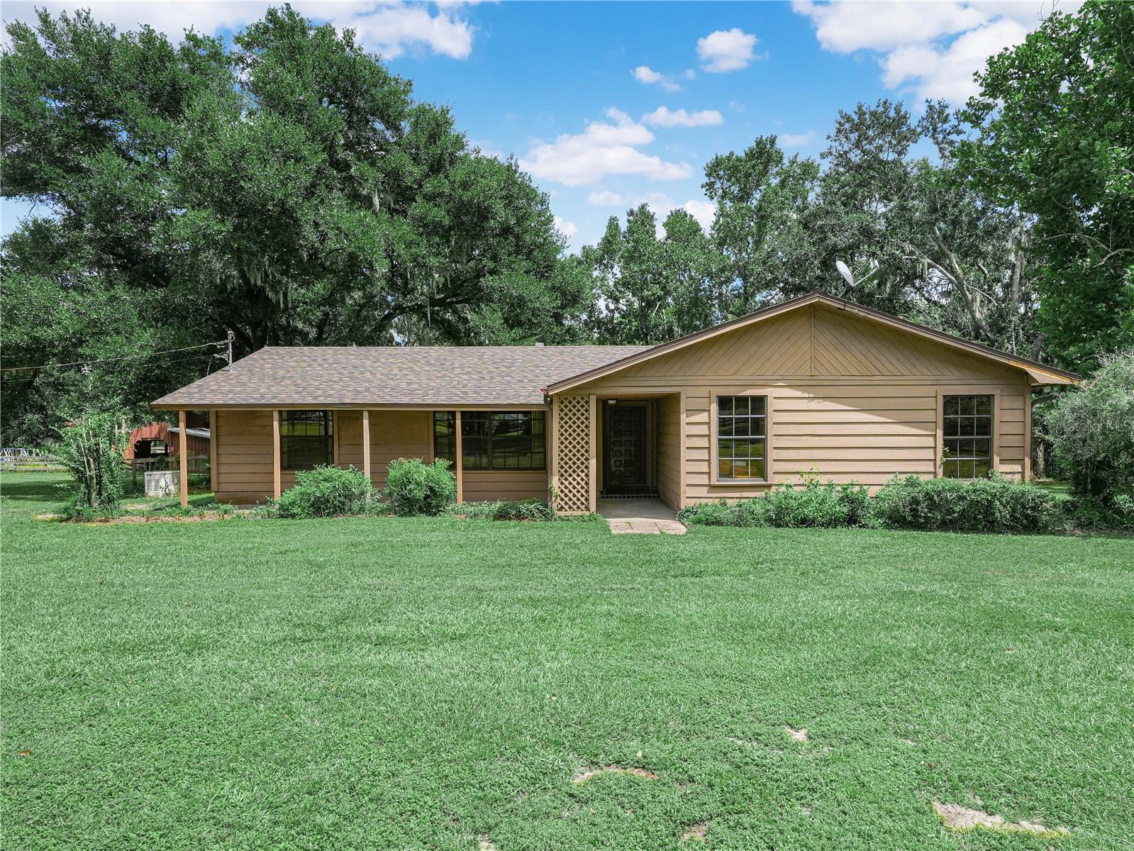 Peaceful Country Living on 5.05 Fenced Acres – Horse Lover’s Dream! Tucked away down a quiet dirt road, this charming 3-bedroom, 2-bath home offers 1,730 square feet of comfortable living space on a fully fenced 5.05-acre parcel—perfect for privacy, pets, and horses!
Step inside to discover a warm and inviting family room featuring beautiful pecky cypress wood, wood burning fireplace framed floor to ceiling with bricks, built-in shelves, and large windows that fill the space with natural light. French doors lead to a spacious screened lanai overlooking the serene backyard—ideal for relaxing or entertaining.
The formal living room offers views of the front yard, while the formal dining room flows seamlessly into the kitchen and family room. The kitchen comes fully equipped with all appliances and closet pantry.
The split bedroom floor plan provides privacy, with the main suite offering a walk-in closet and en suite bathroom. The two additional bedrooms share a second full bath.
Equestrians will love the 4-stall horse barn, and there’s plenty of room to add a detached garage or workshop. The side-entry double car garage accommodates two vehicles.
BONUS: Brand New Roof! Enjoy peace of mind and added value with this recent upgrade.
Whether you're looking for a peaceful retreat, a place to keep horses, or room to grow—this property has it all!