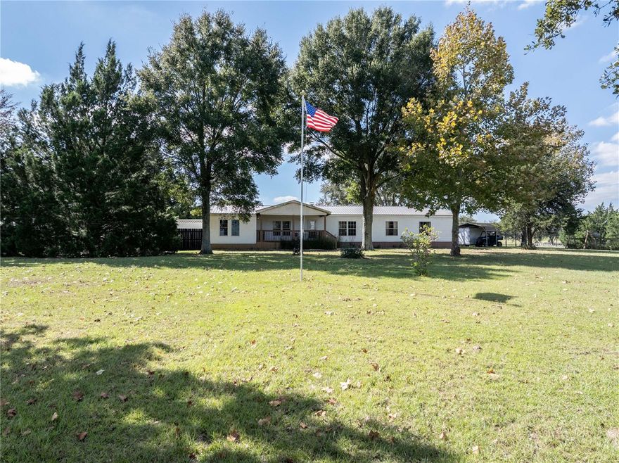 Escape to peace and serenity on this breathtaking 43.8-acre farm, tucked away at the end of a private half mile driveway lined with majestic live oaks. Located just 30 minutes from The World Equestrian Center. This property offers the perfect blend of privacy, functionality, and natural beauty—an ideal setting to live your best life surrounded by open pastures and endless skies. The spacious 4-bedroom, 2-bath home features an inviting open floor plan designed for comfort and convenience. The large kitchen includes an island, extensive counter and cabinet space, and flows into a bright dining area—perfect for family gatherings. An additional dining or bonus area provides flexible space for a home office, den, or hobby room. The huge primary suite offers a walk-in closet and an ensuite bath with a relaxing garden tub and separate shower. Three guest bedrooms—two with walk-in closets—ensure plenty of room for everyone. Outdoor living shines here with a covered front porch and an expansive back deck and porch that span the entire length of the home, ideal for taking in the tranquil views of the surrounding countryside. The entire property is fenced, with multiple functional structures and amenities for both hobby and working farms. There is a carport, three storage sheds, and a pole barn for equipment or feed. The horse barn features a large stall area suitable for several horses, along with three paddocks, each with water. There’s also a cow pen, a chicken coop, and a 35x38 enclosed barn/workshop equipped with electric and A/C—perfect for projects or storage. Whether you’re an equestrian enthusiast, hobby farmer, or simply seeking a private retreat, this property provides everything needed for a relaxed and purposeful lifestyle. Enjoy the peace, beauty, and freedom of country living at its finest.