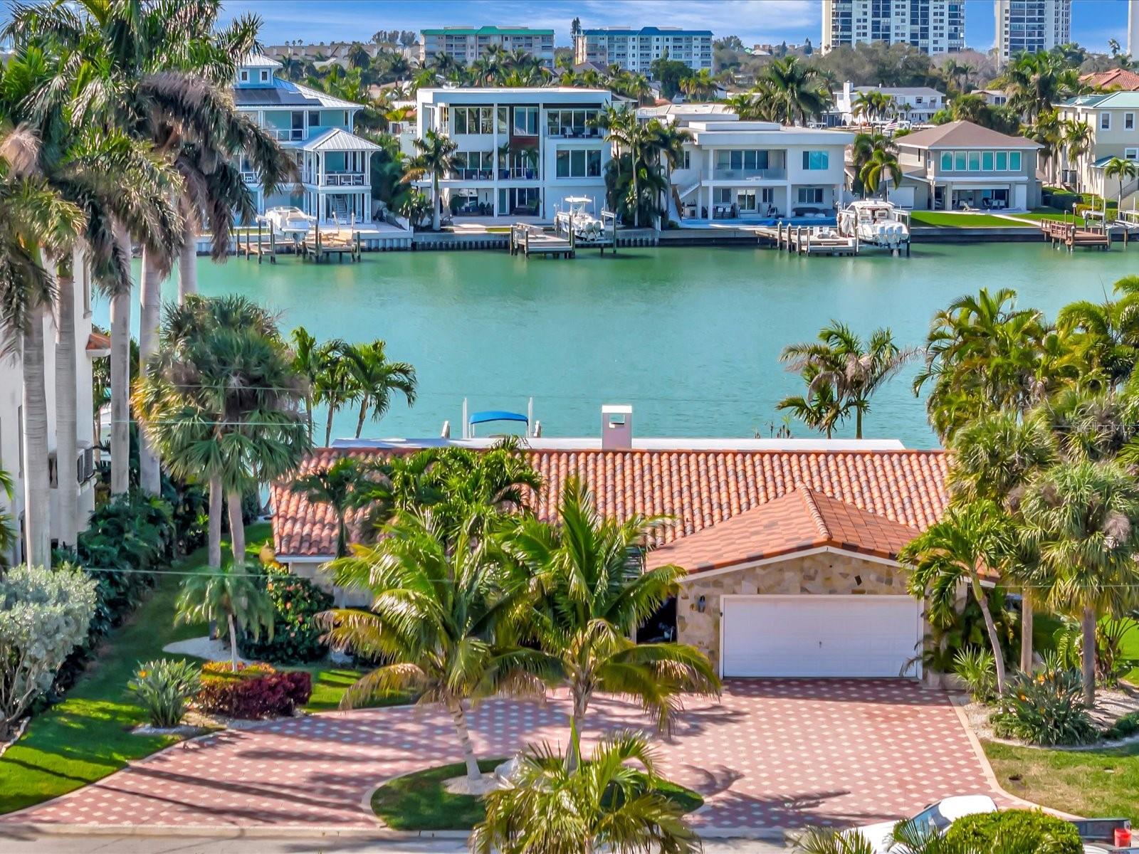 Welcome to your waterfront dream home! This stunning 4-bedroom, 3-bath property invites you in with beautiful views of the water as you step through the front door. The wide and open floor plan creates a sense of spaciousness, accentuated by gorgeous tile flooring that runs seamlessly throughout the house. The heart of this home is the breathtaking and updated kitchen, a culinary haven featuring wood cabinets, a large Quartzite island with seating, top-of-the-line Thor stainless appliances, including a 6-burner gas range, double oven, range hood, refrigerator and dishwasher. The kitchen also boasts a large pantry and a butler's pantry with an additional sink, ensuring ample storage and space for all your culinary needs. Seamlessly open to the kitchen, the spacious family room creates a perfect setting for both entertaining and comfortable everyday living. The living and dining rooms are cozy yet elegant spaces, surrounded by a wood-burning fireplace encased with floor-to-ceiling marble, adding a touch of sophistication to your gatherings. The primary bedroom suite is a luxurious retreat, offering direct access to the waterfront patio through a sliding door. Inside the suite, you'll find built-in drawers and shelving, along with two walk-in closets. The primary bathroom is a spa-like oasis, featuring a large shower with multiple shower heads, a claw foot tub, accented with stacked stone and marble walls and a vanity crafted with live edge wood. The house is intelligently designed with a perfect 3-way split plan, placing 2 bedrooms and a bath on another side and a fourth bedroom with an ensuite bathroom on the opposite side of the home. This ensures privacy and convenience for all residents and guests. Step outside, and the breathtaking outdoor space unfolds. A large composite dock with a lift awaits waterfront enthusiasts, providing easy access to the water. The patio overlooking the water is an ideal spot to relax and entertain, creating a serene atmosphere that makes everyday living feel like a vacation. Additional notable features of the home: a gas tankless water heater, built-in cabinets in the garage, tile roof, and updated lighting throughout most of the home. Indulge in the waterfront lifestyle and make this property your home. Come experience the unparalleled beauty and luxury that this waterfront dream home has to offer! Bedroom Closet Type: Walk-in Closet (Primary Bedroom).