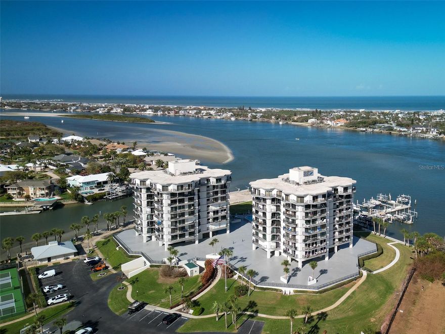 Panoramic river and ocean views from this 7th floor direct intracoastal waterway front condo being conveyed with two boat slips. One slip is 29x17 and is equipped with a 12,000 lb lift featuring steps and side platforms for easy on-lift access, large enough for a 30ft boat. The second slip is 24x12 and features dock fingers on both sides. The marina was recently dredged to accommodate vessels with a greater draft, and electric and water are available at all slips. The unit itself has been immaculately maintained and the views are truly breathtaking as you overlook the ICW, your boats, the island, and the ocean. The open concept floor plan features a bright spacious living room/dining room combo to a kitchen island equipped with a wine fridge and additional seating. There are dual closets in the primary bedroom and built ins with a Murphy bed in the guest bedroom both rooms also offering expansive water views. Additional features include an assigned garage parking space, a large storage closet on the parking level, and a dock box at each slip. Schedule a showing and you will truly appreciate the uniqueness and rarity of this type of property on the beachside. Diamond Head has a abundance of beautifully maintained amenities including a riverfront pool, gym, clubhouse, tennis/pickleball courts, outside grills, fire pit, and much more. Condo fees are $1279/month and marina fees are $800/year per slip. The complex is just a short walk to beach access and shops/restaurants of Flagler Avenue, and about a 15 minute walk west to historic downtown Canal Street. This location gives you quick access to some of the best of NSB.