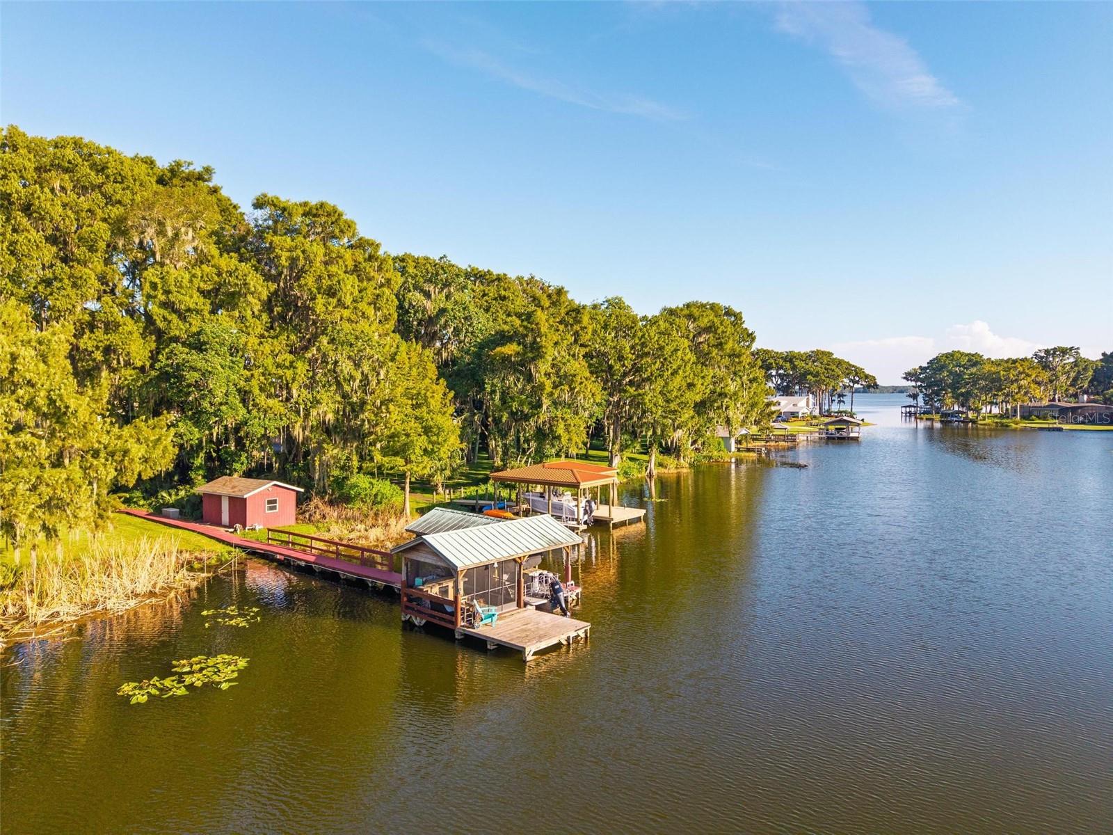 Welcome to Palmora Park ON THE WATER!!! One of Leesburg’s most beloved neighborhoods for generations with NO HOA. With its tree-lined streets, historic character, and reputation as a safe, welcoming community, Palmora Park remains one of the city’s most desirable communities. Residents love the golf cart–friendly lifestyle, neighborhood parks, and close proximity to Downtown Leesburg’s shops, dining, and year-round festivals.
This waterfront gem offers over 3,200 square feet with 3 bedrooms, 2.5 bathrooms, and a versatile split-bedroom layout. The primary suite on the main floor includes a wheelchair-accessible bathroom and a secret walk-in closet hidden behind a mirror. Upstairs, you’ll find a huge secondary master suite—ideal for guests or multigenerational living.
Inside, enjoy multiple living areas, a bright eat-in kitchen with ample storage, and an expansive screened back patio overlooking the water. Outside, the lush backyard leads to your private screened-in dock with a boat lift, the ultimate spot for launching boating adventures or relaxing with unforgettable sunsets over the lagoon that connects to the Lake Harris Chain of Lakes.
Blending Palmora Park’s timeless prestige with modern comfort and rare waterfront amenities, this one-of-a-kind property delivers space, character, and the lifestyle you’ve been dreaming of.
This charming 1949 Home has been completely professionally renovated inside and out by Mastrosimone Construction in 2021/2022.
New Main AC system replaced Jun 2025 including ventilation cleaning and a UV Microbial system for clean air.
The house is also protected by a million dollar termite bond on McCall Pest.
Roof is 10 years old
