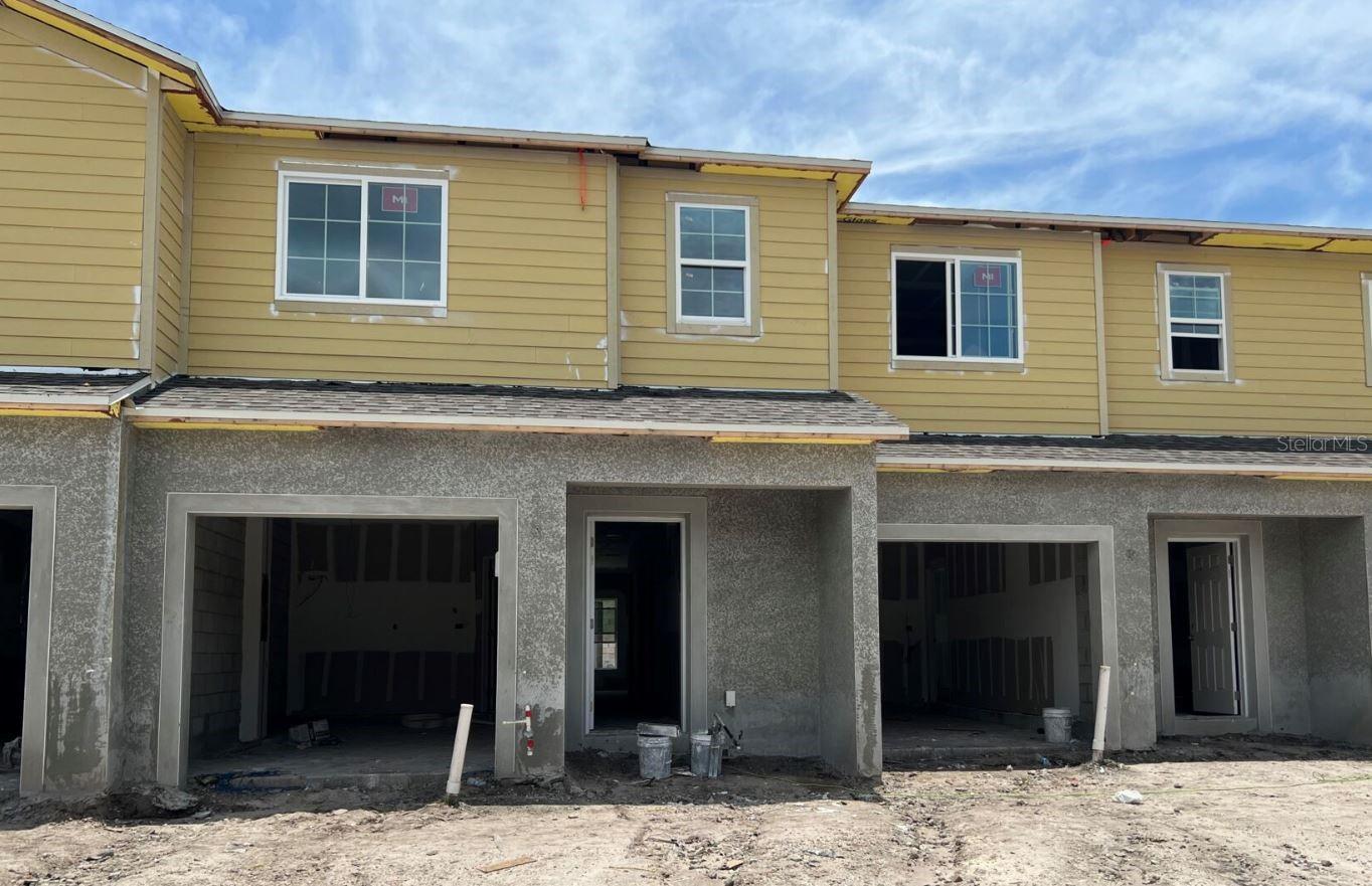 Under Construction. Discover this stunning Quick Move-In townhome at 14933 Harvest Street in Orlando. This thoughtfully designed townhome offers 3 bedrooms, 2.5 bathrooms, an open-concept living space, a modern kitchen with upgraded cabinetry and stainless steel appliances, a private outdoor patio, and an attached 2-car garage for convenience and extra storage The townhome’s well-planned floorplan maximizes functionality while maintaining an inviting atmosphere. The open-concept design connects the main living areas, creating an ideal environment for family gatherings and everyday activities. The owner’s suite upstairs provides a comfortable and private retreat. This desirable Orlando neighborhood offers excellent proximity to local parks, making it perfect for outdoor enthusiasts and families who enjoy recreational activities. Experience the joy of being the first owner of this brand-new townhome, with everything fresh, modern, and ready for move-in. The quality construction and attention to detail are evident throughout, ensuring a beautiful and functional space to call home!