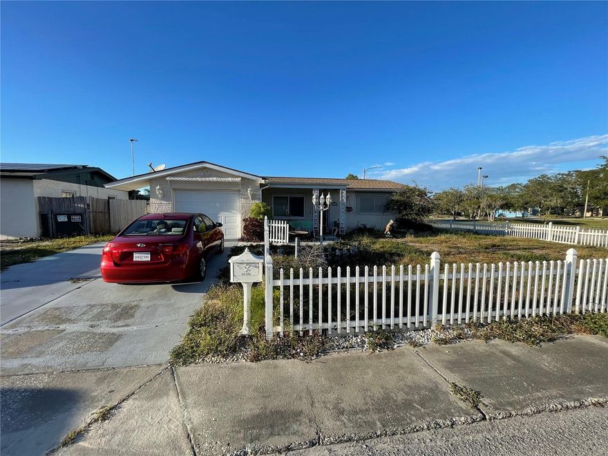 Port Richey opportunity awaits! This home features modern core systems, including a 2-year-old heater, water tank, washer, dryer, and electrical panel. The flexible layout includes a converted family room, offering potential for a third bedroom. Enjoy beautiful hardwood floors throughout, with laminate in the kitchen and dual stand-up shower bathrooms. The kitchen boasts charming painted wood counters with gold accents. Outside, a private pool area offers a blank canvas for your enjoyment. The roof is in good condition but offers an opportunity for hurricane-ready upgrades. Ready for minor cosmetic updates and your personal touch!