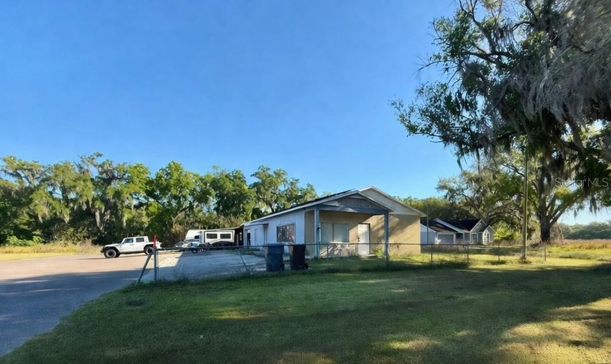 Fantastic opportunity to own an affordable and versatile commercial property located at 4418 E County Rd 542 (K-Ville Rd). Situated on .92 acres and fully fenced, this property offers ample space for a variety of uses.  The 1,770 sq ft building has been significantly updated, with most flooring recently redone, a spacious expanded kitchen area, and a fully renovated bathroom. The structure also includes a garage and a separate carport that has been enclosed on two sides, providing additional covered workspace or storage. Previously operated as a used car dealership and more recently converted to a residential use, this property offers excellent potential for mixed-use, small business operations, auto body/shop use, office space, or continued residential use.  Please verify with County what uses would be acceptable.

The lot provides plenty of parking and maneuverability, making it ideal for business operations requiring vehicle access or storage.

Surrounding uses include a junkyard to the left, residential property to the right, a mobile home park across the street, and a railway located behind the property. Conveniently located near the Polk Parkway with easy access to Lakeland, Auburndale, and Winter Haven, this is a centrally located property with strong accessibility.

If you’re looking for affordable commercial space with flexibility and room to grow, this property is a must-see.