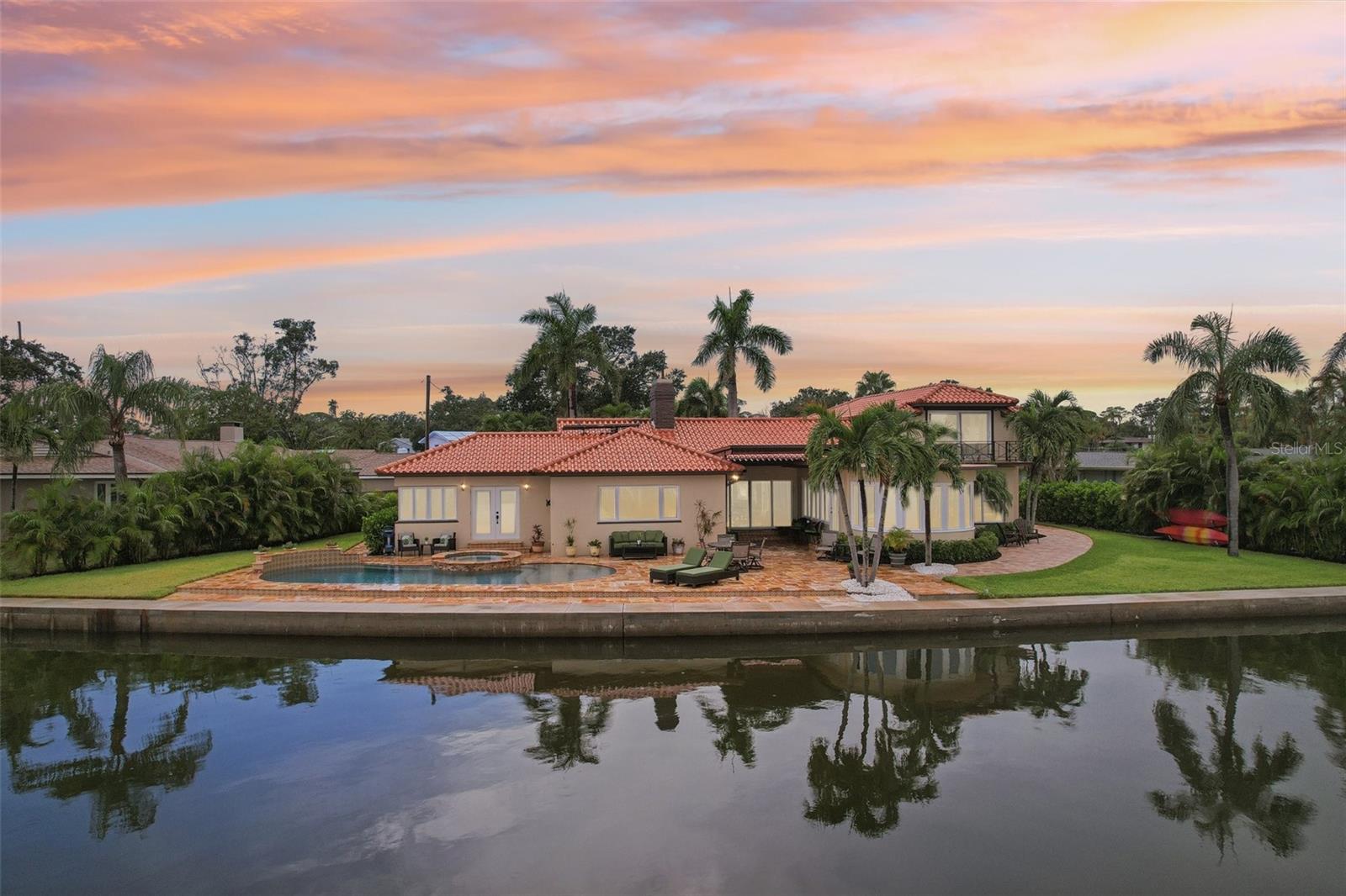 Boater’s Paradise on Sailboat Water – This beautifully renovated home blends historic charm with modern luxury, tucked away on a quiet cul-de-sac with 150 feet of protected sailboat water and unrestricted access to the Gulf. In 2025, the property underwent a complete renovation, pairing timeless details with fresh, high-end finishes. Recent upgrades include a brand-new pool and spa finished in travertine pavers, an oversized seawall, and a new A/C system—making this a true turn-key waterfront retreat. Fresh exterior paint, crisp landscaping, and sweeping water views greet you at arrival. Step inside to find a dramatic solarium and great room, both designed to showcase the water. The great room features a cozy fireplace and expansive sliders that lead directly to the waterfront patio. The renovated kitchen and dining area take full advantage of the views, while the home’s two main-level master suites each offer comfort and privacy, including one overlooking the water. A spacious laundry room, guest bath, and oversized 23-foot garage complete the main level. Upstairs, two bedrooms and a full bath provide space for family or guests, with the east bedroom opening to a private balcony and sundeck—perfect for sunrise coffee or sunset cocktails. The outdoor living spaces are equally impressive, featuring a large travertine deck with a covered area for entertaining, surrounded by mature tropical landscaping and a wide-cap seawall stretching approximately 150 feet—an ideal setting for enjoying the open water views. Original Moravian tile floors, crown molding, and abundant natural light preserve the home’s character, while thoughtful updates—including a solar water heater assist and new main waterline—bring peace of mind. Set on a peaceful cul-de-sac location, yet only minutes to downtown St. Petersburg, Tropicana Field, the beaches, and major highways—this is a rare opportunity to own a truly special sailboat-water property with timeless charm and modern upgrades.
