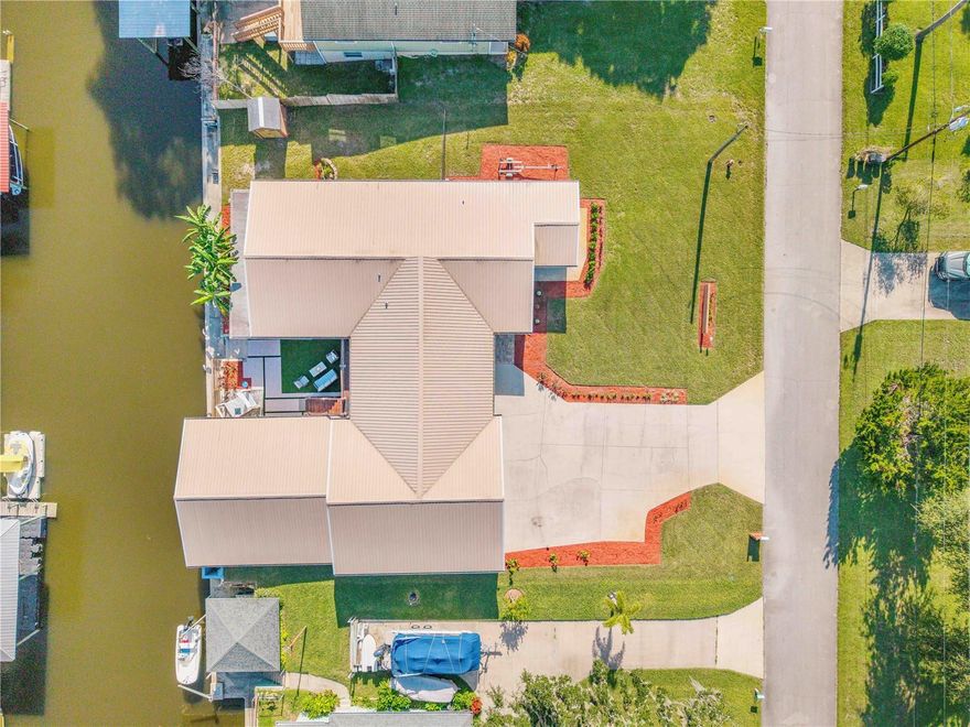 Tranquil Canalfront Living in Waterway Park — Your Private Coastal Retreat

Escape the hustle and bustle of the Intracoastal and enjoy peaceful canalfront living on 100 feet of serene waterfront in Waterway Park. No traffic, no crowds—just calm water, gentle breezes, and the freedom of no HOA in unincorporated Volusia County.

This thoughtfully designed home offers over 3,000 sq ft of living space with a bright, open floor plan that blends comfort, style, and functionality. The main level features a spacious primary suite with private balcony, a chef-inspired kitchen for gatherings, and open dining and living areas that flow naturally toward the water. Additional spaces include a home office, laundry room, and breakfast nook—making everyday living effortless.

Downstairs, a large family room and three bedrooms provide plenty of space for family, friends, or extended stays—everyone enjoys privacy without feeling crowded.

Step outside to your private courtyard oasis, complete with low-maintenance turf, composite decking, a cabana with mounted TV, hot tub, and multiple seating areas—perfect for quiet mornings by the canal or relaxed entertaining. Boating enthusiasts will love the cut-in boathouse, offering covered storage for two boats or personal watercraft and ready for sunset cruises or weekend fishing trips.

Lovingly remodeled and updated, this home combines modern comfort with relaxed coastal charm, delivering the ultimate peaceful waterfront lifestyle—far from the congestion of the Intracoastal, yet just minutes from local amenities and the beach.

Waterway Park is ready for you—secure your slice of tranquil Florida living today.