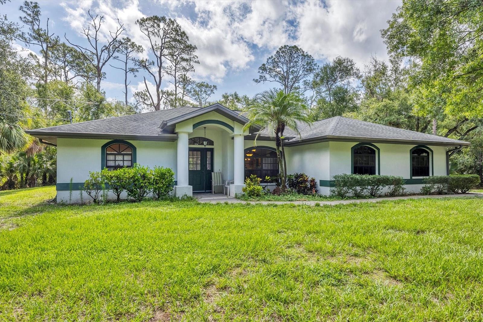 Discover your private slice of paradise in North Port Estates! Nestled on 3 wooded acres, this beautifully maintained home offers privacy, space, and versatility—perfect for those seeking a rural lifestyle without sacrificing convenience. Built by Tenbusch Homes in 2000, this 3 bedroom, 2 bathroom POOL HOME offers over 2000 square feet of living space, an oversized 2-car garage, and a thoughtful floor plan designed for both everyday living and entertaining. Step through the double door entry into a spacious layout featuring a split-bedroom design, ensuring privacy for your guests and family members. The large kitchen offers solid wood cabinetry, quartz countertops, a pantry, and a breakfast bar that opens to a sunny breakfast nook. The kitchen flows seamlessly into the family room, highlighted by a striking stone wood-burning fireplace, perfect for cozy evenings at home. Additional living areas include a formal dining room and formal living room, both finished with low-maintenance vinyl flooring, while the kitchen and main living areas are finished in tile. All three bedrooms are generously sized, and both guest bedrooms feature walk-in closets. The 25x13 primary suite offers dual walk-in closets and a spacious en-suite bath with dual vanities, a jetted garden tub, and a walk-in shower. Whether you're relaxing indoors or entertaining outdoors, this home was made to impress. Step outside and enjoy your screened saltwater pool, complete with a brand-new pool cage installed in 2023. An outdoor shower adds a resort-style touch, while the backyard offers room to roam, play, or garden. A detached shed with running water and electric adds functionality and extra storage. Additional updates include: AC system replaced in February 2025, Roof replaced (2016), drain field replaced approximately 5 years ago, new water softener and reverse osmosis system (2024). Best of all, the property is not located in a flood zone, offering peace of mind year-round. With Agricultural zoning, you can fully embrace country living. Bring your horses, start a garden, or raise chickens, all while being just minutes from I-75, shopping, dining, Gulf beaches, and area parks. If you’ve been dreaming of space, privacy, and the freedom to live your way, this North Port gem is calling you home.