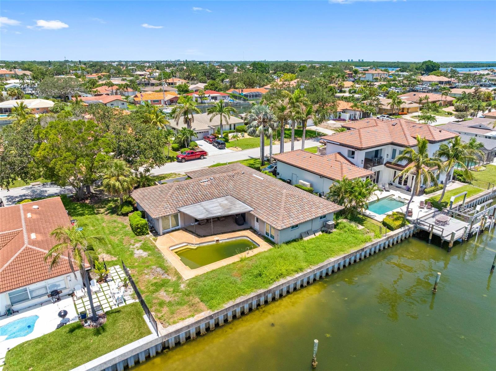 Welcome to 1962 Hawaii Ave NE – a rare chance to create your dream home in one of the most desirable waterfront neighborhoods in St. Petersburg. Situated on a spacious 10,224sqft lot with 91 linear feet of waterfront, this property offers direct access to open water with no fixed bridges – a boater’s dream! The canals allow for sailboats and power boaters or both. Vinyl seawall was last replaced in 2004 by a local reputable company. Seller had it recently inspected and the report came back clean, report is available. This side of Venetian Isles is more desired - enjoy the morning sun and skip the afternoon heat. The existing 2,180sqft home features 4 beds, 3 full baths, solid bones and an in-ground pool, ready for your vision and renovation touch. Home was affected by flooding from Hurricane Helene - the only time the house has ever flooded in the 34 years the seller has lived there. Whether you're looking to restore, expand, or rebuild, this is the ideal canvas in an unbeatable location. Located on one of the best streets in the area, you'll enjoy peaceful surroundings, upscale homes, and the unbeatable Florida lifestyle. 50% of owners in the neighborhood are rebuilding, according to the HOA board, making it less competitive and more desirable for a luxury waterfront buyer looking to buy a new build. Only 15 minutes away to downtown St. Pete and close enough to catch a flight at TPA in 25 minutes. Buyers to verify setbacks and square footage. Buyers to do due diligence on FEMA 49% rule and renovating flooded properties. Waterfront properties with this much potential and flexibility are hard to find – don’t miss your chance to invest in a premier piece of paradise.