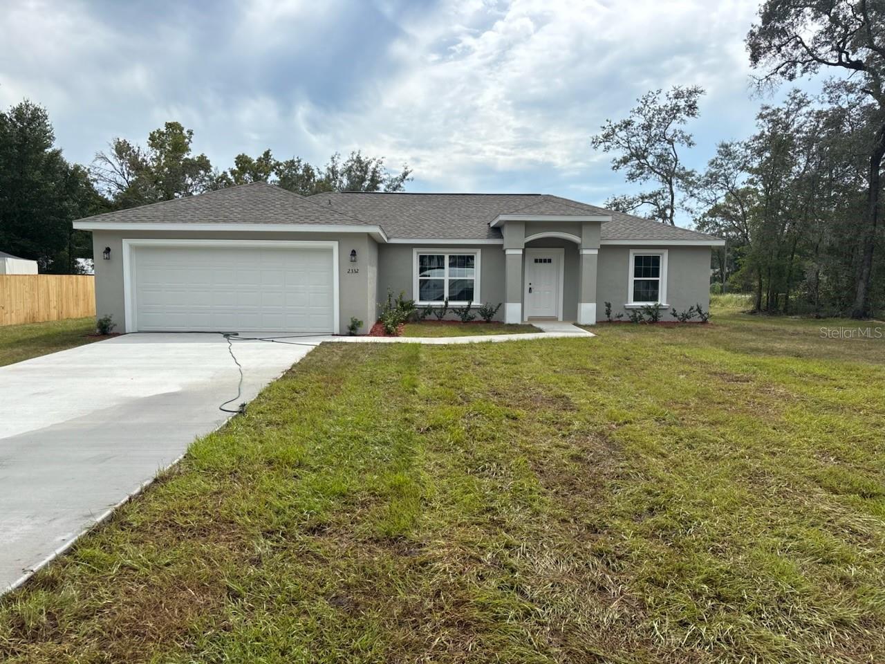 NEW CONSTRUCTION. MOVE-IN READY! This Isla Bella Model offers 3 bedrooms, 2 bathrooms, and 1,530 square feet of comfortable living space on a large corner lot measuring one-third of an acre. The home is built with solid concrete block construction and a 30-year architectural shingle roof for long-lasting durability. Inside, you will find energy-efficient double-pane windows, luxury vinyl plank flooring throughout, and a vaulted ceiling in the living room that adds an open and airy feel. The kitchen is upgraded with a deluxe cabinet package, soft-close drawers, granite countertops, a pantry, and a subway tile backsplash, all complemented by stainless steel appliances. The master suite is thoughtfully designed with a tray ceiling accented by crown molding, a spacious walk-in closet, and a private bathroom featuring two linen closets, a privacy window, and an oversized 5x5 glass-enclosed shower with dual shower heads. The guest bathroom features a tub and shower combination with upgraded, marble-look tile. Additional conveniences include a laundry room with cabinet upgrades, a covered patio for relaxing outdoors, and an attached 2-car garage with opener and remotes. This property comes with a 10-year structural warranty, no HOA fees for freedom, and sits in flood zone X, which is high and dry and does not require flood insurance. The lot also features a privacy fence along the back and left side, making it perfect for both comfort and outdoor enjoyment.