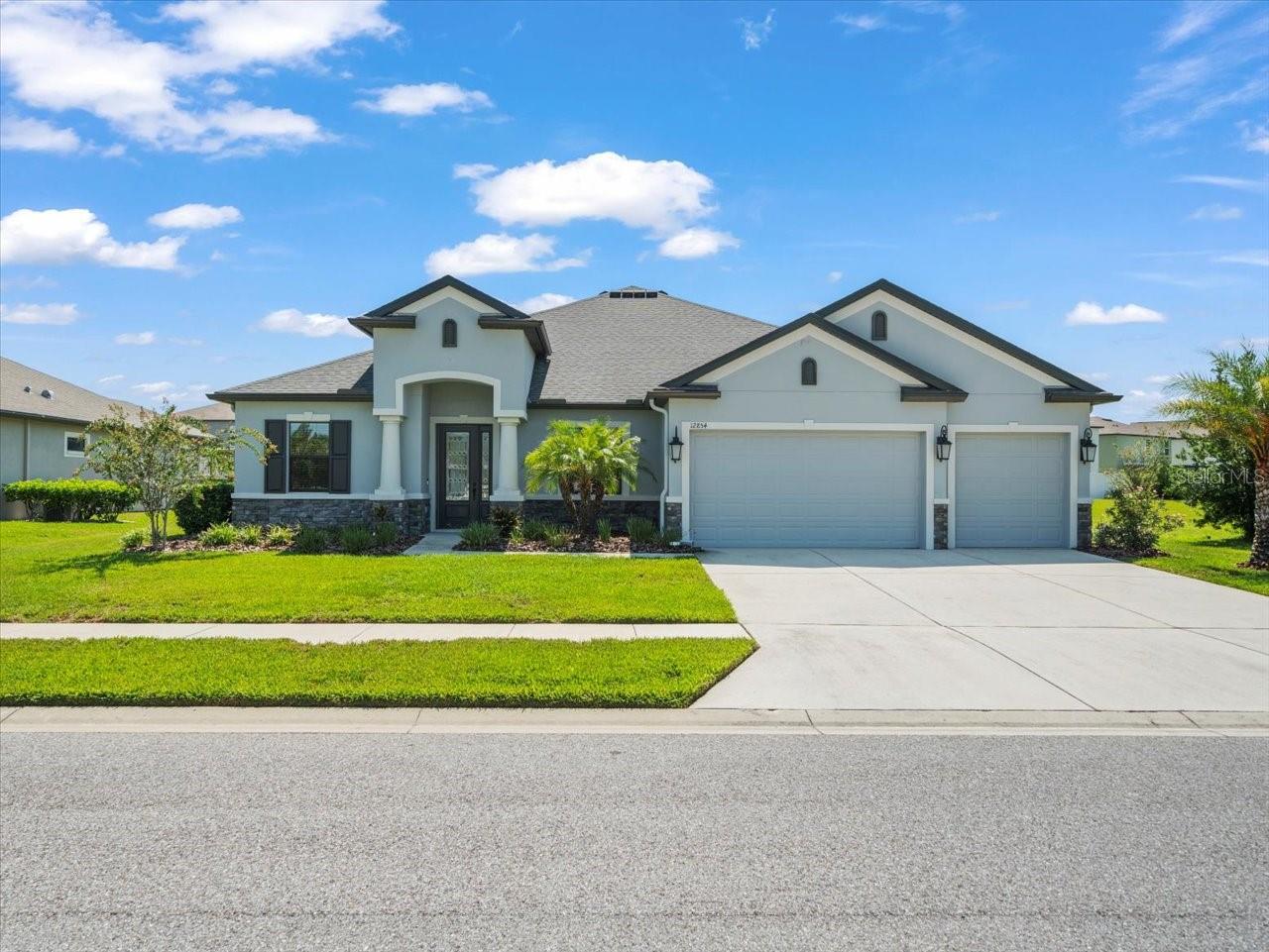 This exquisite 4 bedroom, 4 bathroom, 3-car garage residence is the perfect blend of luxury, space, and functionality—boasting over 3,000 sq ft of beautifully upgraded living space on a premium 0.35-acre lot in the highly sought-after Villages of Avalon master-planned community. Step through the 8-ft front entry door and be welcomed by soaring ceilings, 6" baseboards, and elegant upgraded tile flooring that flows throughout the main living areas. The home features two full primary suites, each offering walk-in closets and spa-inspired en-suites—perfect for multi-generational living or luxurious guest accommodations. The main primary suite showcases an oversized walk-in shower and dual vanities for a true retreat feel. The heart of the home is the gourmet kitchen, equipped with double ovens, an expansive kitchen island, upgraded cabinetry, high-end stainless steel appliances, and gorgeous upgraded granite and quartz countertops throughout. A custom solid stone backsplash adds striking elegance and timeless design. The open-concept great room is anchored by a dramatic electric fireplace wall with a custom stone surround and an encased TV—a perfect space for cozy nights or entertaining in style. Step outside to your private backyard oasis, where a custom saltwater pool with a waterfall feature awaits. The pool is fully caged, surrounded by upgraded stone pavers, and includes a large covered lanai area—ideal for relaxing or hosting friends and family in Florida’s beautiful weather. Located in the desirable Villages of Avalon, a deed-restricted community with sidewalk-lined streets, a resort-style pool, clubhouse, and fitness center, plus easy access to the Suncoast Parkway for a quick commute to Tampa. The neighborhood is surrounded by conveniences such as shopping, dining, healthcare, and outdoor recreation like Weeki Wachee Springs and Anderson Snow Park. There are too many upgrades to list—request the full feature sheet! Homes like this rarely come available in the Villages of Avalon. Schedule your private showing today and experience the ultimate in luxury and lifestyle! No CDD fees. This meticulously maintained home shows like a model...no need to wait for months for a home to be built...this is it!!!