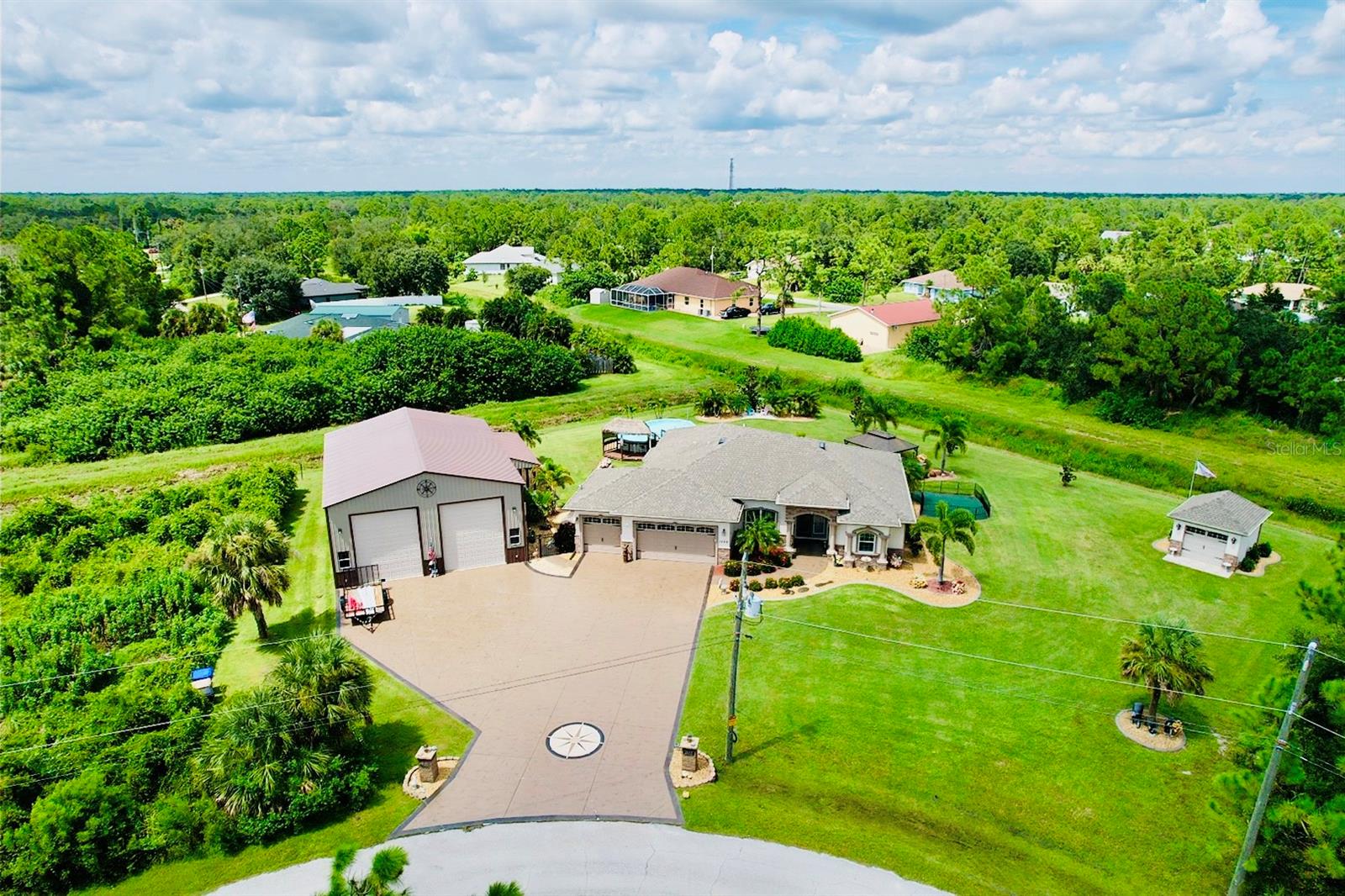 Meticulously Maintained Home and Yard on .79 Acres!!! These homeowners did an amazing job at taking care of this piece of paradise. Starting with the exterior... There is a 36x50 Metal Outbuilding with a Loft. Able to contain a Class A or Fifth Wheel RV along with other vehicles/boats! Doors on building are 14ft high and 12ft wide!! 3 Car Garage doors to the main house are 8ft. A/C has the blue light system/7 years new, and there is a a wall unit in Master bedroom thats 1 yr. old for those who like it really cold! Whole house hurricane shutters! The land is high and dry sitting at 24ft above flood level. Whole house Generac Generator is 22KW! Gorgeous Park like setting! Shed for storage on the North side of property! 8 Zone Sprinkler System, approx. 80 heads. Talk about a calming atmosphere while relaxing in the Heated Swimming Pool or Spa! Outdoor heated Shower! There is also an Outdoor Kitchen that makes it great for Entertaining. Owners are leaving the Fire Table & Stools outside of the Lanai! Many areas to sit outside under the metal building or in the Tiki Bar next to the Pool!! Such a great atmosphere! Now.... the Interior, Upon entering, you will notice the nicely landscaped entry way leading up to the front doors. Tile throughout the main rooms of house, formal dining room, NEW CARPET in all bedrooms! Granite Kitchen and Bathrooms! Appliances that are 7 years old- dishwasher & refrigerator, microwave & oven are 2, washer & dryer are 3 years. Living room and family room have Sliders to the lanai!