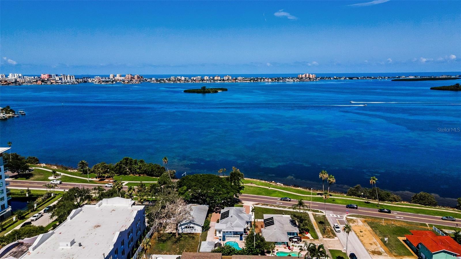 Amazing water views, spectacular sunsets, relaxing front, side and back porch to sit and enjoy natural beauty, dolphins, birds, boats, and evening lights of Clearwater Beach or holiday fireworks, await the lucky buyer of this pristine property located in the heart of Clearwater/Dunedin passage way along the St. Joseph's Sound. Outdoor activities abound with walk/bike trails along Edgewater Drive and the Pinellas Trail within a few blocks. Begin or end the day with a splash in the beautiful in ground pool. Bring the beauty of the surrounding landscape views indoors where many windows surround the interior offering sunlight and scenery from the 9 Ft. ceiling space. Use the remote operated awning to side porch for more or less exposure! The open floor plan accommodates any lifestyle with renovated kitchen, wood floors, indoor laundry, den/office area with extra sleeping space, bonus room for arts, crafts, library or even a small Accessory Dwelling Unit with its own entrance to the outside. The circular drive and long driveway provide ample space for parking multiple vehicles & access to the separate garage. Whether one wishes to launch a kayak across the street or stroll to quaint downtown Dunedin, this location is prime for convenience to eateries, schools, shops, and taking advantage of truly Florida Paradise living.