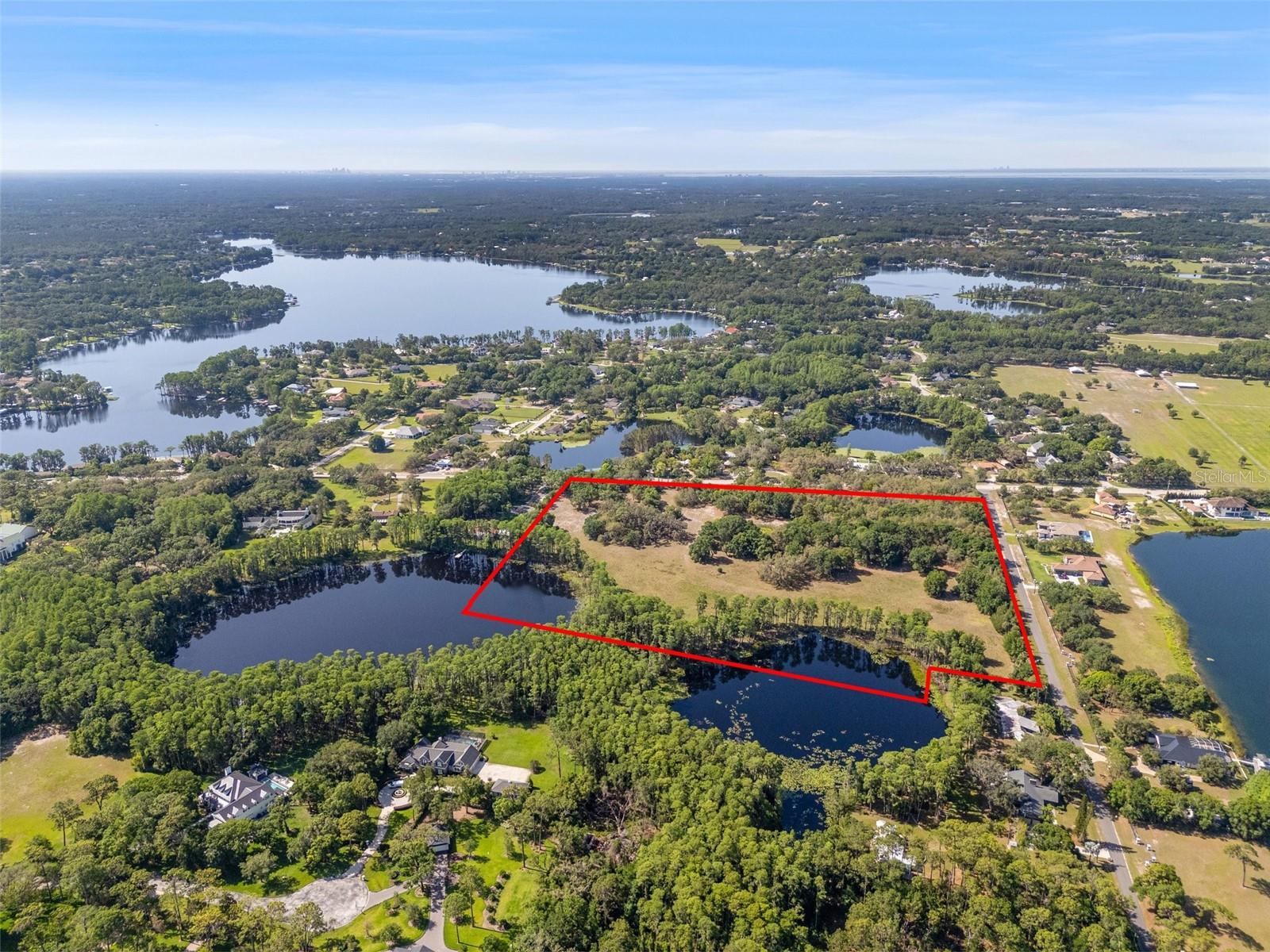 Where Legacy Meets Luxury — This rare 22.3-acre lake front property presents a once-in-a-lifetime opportunity in the heart of Tampa Bay. Curate a lifestyle as distinctive as your vision—whether you're dreaming of a private equestrian retreat, an ultra-luxury estate, or an exclusive residential enclave, this exceptional land adapts to your highest aspirations. Surrounded by private estates—including Tampa’s $38.5 million dollar residence—and world-class equestrian facilities, this expansive lakefront property is ideally located in Odessa, one of the region’s most prestigious and sought-after enclaves. Spanning three conjoined parcels, the lot features over 1,000 feet of water frontage along Keystone’s twin lakes, including the spring-fed, 9-acre Lake Martha, plus a tranquil on-site pond. With 17.01 acres of uplands and 5.29 acres of wetlands, this breathtaking property offers a pristine canvas for bringing your vision to life, while having the ease of 2 active electrical boxes and 1 operational well currently on property. Enjoy peaceful serenity just 30 minutes from Downtown Tampa, with quick access to the Veterans Expressway, Tampa International Airport, and top-rated schools. In an area that continues to experience strong demand for luxury living, this legacy property offers endless potential. NOTE - Please do not enter the property without permission.