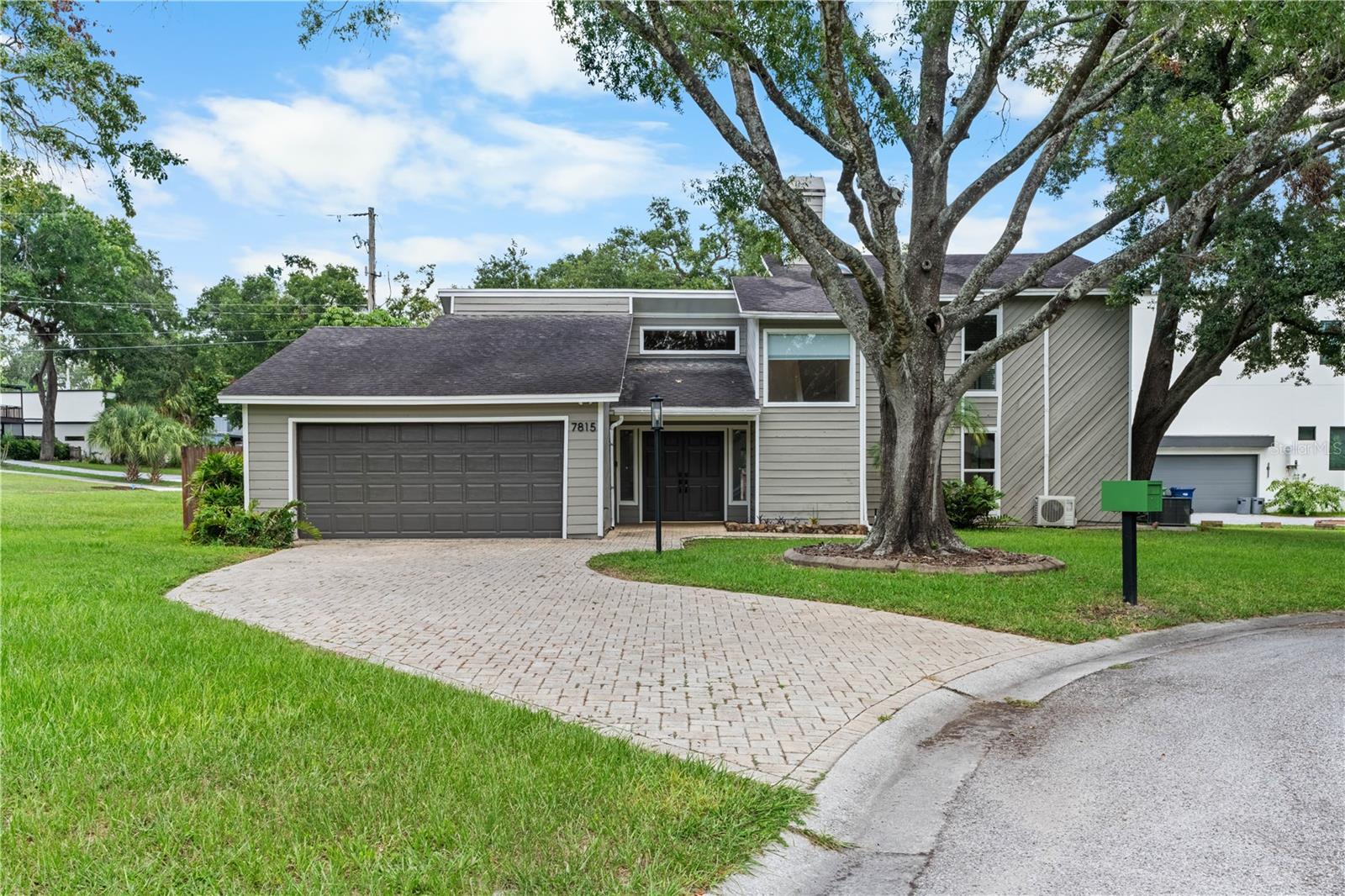 Spacious 3 bedroom, 2 bath, 2-car garage home with 1,616 SF of living space and captivating Hillsborough River views from the second-story balcony off the primary suite. Step inside through double front doors into a welcoming foyer. Step down into the living room which boasts of a floor-to-ceiling stone fireplace, vaulted wood ceiling, and glass doors opening to a fenced patio and backyard—perfect for barbeques and outdoor gatherings. The living room flows into the dining area, which also opens to the patio. The gourmet kitchen features a built-in oven, gas cooktop, wall-to-wall cabinetry, pantry, and breakfast bar adjoining the dining room. A tiled hallway leads to two bedrooms and a full hall bath with tub/shower combo. Upstairs, the primary suite offers a vaulted wood ceiling, glass doors to a covered balcony, and a luxurious en-suite bath with double sinks, a Jacuzzi tub, a separate shower with skylight, and built-in shelving. Enjoy the river life—just a 3-minute walk to the City of Tampa Park to watch fish and manatees, or a 5-minute drive to Lowry Park boat ramp. Conveniently located off Florida Ave with easy access to I-275, and only 0.7 miles from Lowry Park Zoo for family fun.