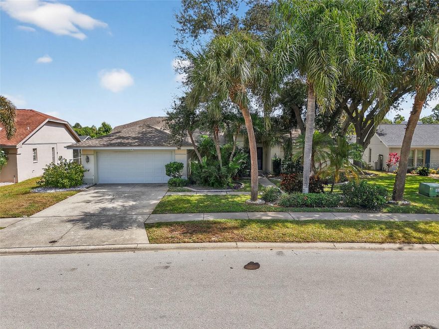 Welcome to this four-bedroom, three-bathroom pool home in the heart of Holiday in the Amblewood community of Gulf Trace, perfectly positioned on a tree-lined conservation lot offering both privacy and tranquility. Once the model home for the community, this residence showcases thoughtful design, spacious living, and just under 2,500 square feet of beautifully maintained space. Step inside through the foyer entrance with a convenient coat closet and be greeted by high ceilings and a light, bright interior filled with natural light from the large sliding glass doors overlooking the pool area. Enjoy entertaining in the formal dining area, while the galley kitchen - offering plenty of cabinet storage - opens to the family room and breakfast nook. The family room features a cozy wood-burning fireplace, creating a warm and inviting space for gatherings. The split floor plan provides both comfort and privacy, with a spacious primary suite featuring an en-suite bathroom complete with a dual-sink vanity, step-in glass-enclosed shower, and private water closet. A dedicated office is located just before the garage, perfect for working from home, and the laundry room includes additional storage for convenience. One of the back bedrooms includes an attached private bathroom, making it ideal for guests or multi-generational living. The additional bedrooms are nicely sized and share access to a third full bath. Step outside to your private screened-in pool area, ideal for year-round enjoyment. The outdoor space includes a covered area for al fresco dining, a wet bar, and a fenced backyard backing up to a peaceful conservation view - the perfect setting to relax or entertain guests. Located close to shopping centers, dining options, and just a short drive to the Gulf beaches, this beautiful Holiday home offers the best of Florida living - space, privacy, and convenience in one exceptional package. Schedule your private showing today!