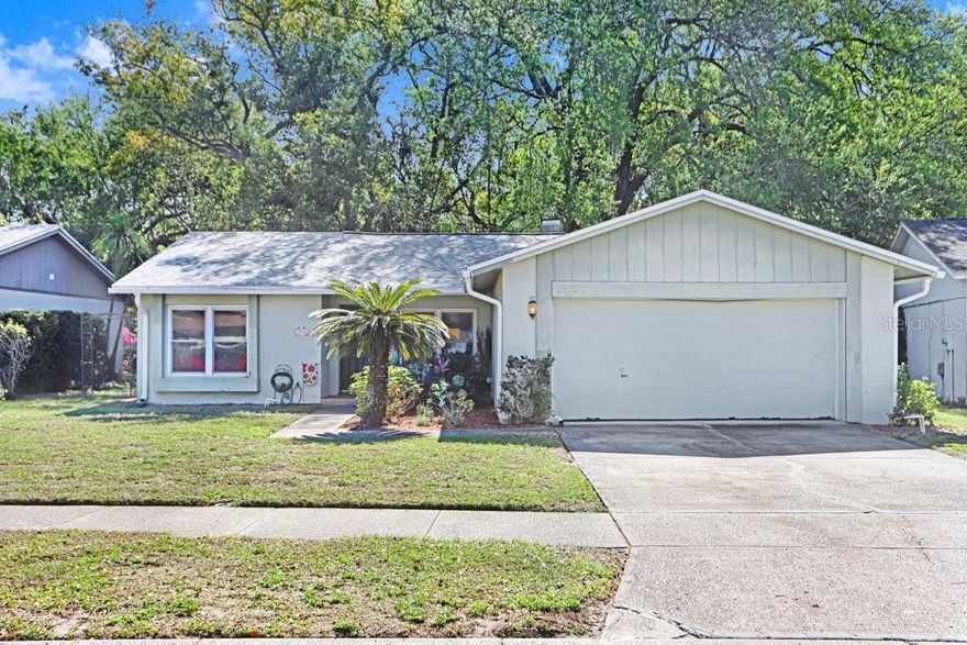 Enter this cozy 3/2/2 home with a wood burning fireplace for those cold Winter evenings. Split floor plan. The home has a new roof Sept, 2025, new gutters Nov 2025, 80 gal water heater, impact windows tilt inwards for cleaning, blown in insulation & mylar in the attic, rear sliding doors have impact windows, Front and garage doors have hurricane impact extra long screws and bolts. the bottom kitchen cabinets have pull out drawers. Sit in your own oasis with the Curiosity Creek flowing behind  the large backyard. There is a wooden deck for those holiday get togethers or just relax in the quiet serene surroundings.