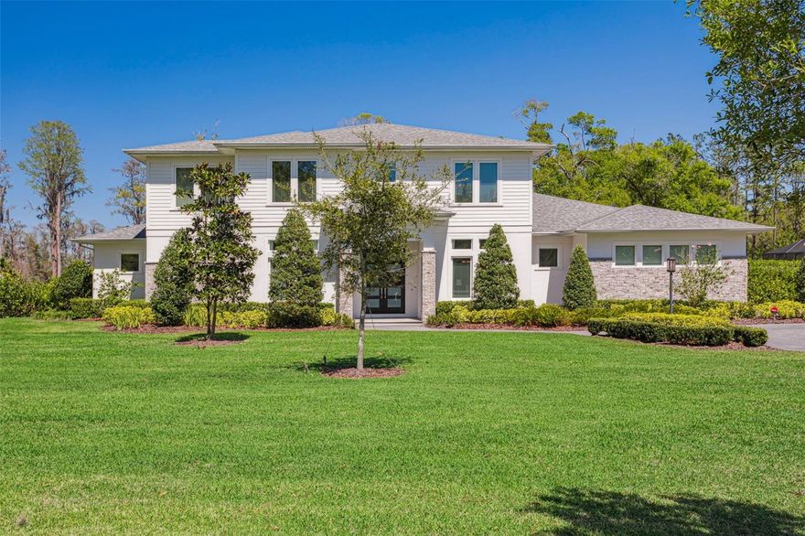 Enjoy the ultimate lake lifestyle in a rural setting with this modern farmhouse style home by Bayfair Custom Homes on the luxury lakefront gated community of Carencia Lakes in the heart of Odessa!  This is truly the best of lakefront living featuring an open floor plan, tons of natural light, and fantastic outdoor living space with over an acre of land.   The living area has large wood accent beams, solid wood shelving, and Herringbone tiled wall with linear gas fireplace and surround speaker system.  The sliding doors fold into the wall creating an uninterrupted flow to lanai and pool.  The gourmet kitchen features 42-inch upper cabinets plus stacked overhead cabinets to the ceiling that have lighting and glass panes.  There is also a massive island with pendant lighting that seats 4-5 people, quartz countertops, subway backsplash, under cabinet lighting, stainless JennAir appliance package including a built-in fridge, gas range & hood, and stainless farmhouse style sink.   In addition, there is an enormous butler pantry prep area with tons of storage and a large walk-in pantry with custom shelving.  A mud room area is also nearby with upper and lower cabinetry, solid wood bench and Wainscot paneling.  A large den (currently being used as a home gym) awith a tray ceiling, decorative wood ceiling beams, speaker system, dry bar with upper/lower cabinets and a beverage fridge also has access to the lanai. The downstairs primary bedroom has exquisitely crafted coffered ceilings, access to the lanai, and dual walk-in closets with closet systems. The primary bath has a long vanity with dual sinks and drawer banks, free standing soaking tub, large frameless glass shower with seated bench dual shower heads, & water closet.  There is also a downstairs guest bedroom with walk-in closet on the ground floor, a full bath with standup frameless glass shower, and powder room with glass subway tile accent walls.  The upstairs features a loft area, and four large bedrooms (big enough to fit king beds) each with walk-in closets and full bathrooms.  The covered lanai has solid wood paneling in the ceiling, outdoor speaker system, and outdoor kitchen.  With multiple TV’s and enough room for multiple patio furniture sets this area is perfect for relaxing and entertaining!  The saltwater pool and spa completely screened in with the lanai and is gas heated.  Beyond the pool is a custom playground with pavered walkways and turf.  Finally, you have the serene natural beauty of Lake Politz - a private, natural lake only accessible to owners in Carencia Lakes that has non-motorized watercraft access.  Other features include: over $350k in improvements after purchase; 10-11 foot ceilings; wood floors and stairs throughout; impact windows; Generac generator; security cameras; tankless gas water heaters; 3 car side entry garage; 8 foot doors; large laundry room with upper and lower cabinetry, granite counters, and storage closet;  garage is air conditioned, has epoxy flooring, a charging station, filtration system, and suspended loft storage; long brick paver driveway with roundabout.  This cozy community with a total of 19 homes is conveniently located conveniently close to shopping and retail and minutes to the Veterans Expressway.  Come visit this home and witness yourself the excellent attention to details and craftmanship of this home and the beauty of the peaceful lakefront views!