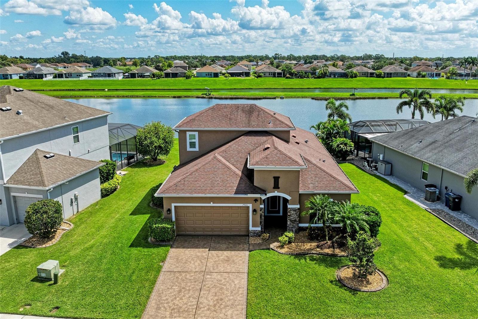 Welcome to this beautifully maintained 4-bedroom, 3-bathroom home with a 2-car garage and nearly 2,400 sq ft of living space, located in the highly desirable gated community of Copperstone. From the moment you arrive, you’ll notice the professional landscape curbing, a decorative stained driveway, and a stunning glass front door. Inside, the home features a split floor plan with the master suite privately tucked away and offering peaceful water views, a spacious walk-in closet, and a spa-like bath with dual sinks, granite countertops, and a tiled walk-in shower. On the opposite end of the home, you’ll find three additional bedrooms along with a full bathroom featuring dual sinks, granite counters, and a tiled shower/tub combo. The main living areas are finished with tile flooring throughout for easy care and style. The gourmet kitchen overlooks the family room, making it perfect for entertaining. The kitchen is equipped with granite countertops, pendant lighting, a tiled backsplash, stainless steel appliances, and tall espresso cabinets with crown molding. Just off the kitchen, enjoy easy access to the screened lanai, where you can relax and take in sunrises over the water. The oversized backyard has plenty of room for a pool and can be fenced for additional privacy. Upstairs, a large bonus area with a full bathroom offers endless possibilities—ideal for a home theater, playroom, or guest suite. Additional features include gutters, hurricane shutters, and an irrigation system. The home is ideally situated on a quiet dead-end street with minimal traffic for added peace of mind. Copperstone residents enjoy a wealth of community amenities including two resort-style pools, a playground, sport courts, a clubhouse, and secure gated access. Families will love being within walking distance to a new elementary school and high school. Perfectly located, Copperstone is just minutes from shopping, dining, Fort Hamer boat launch, and two new county parks. With quick access to I-75, you’ll be at the beaches, Tampa, St. Pete, Sarasota, or two major airports within 45 minutes or less. This home offers the perfect balance of space, style, and community living. Don’t miss your chance to call Copperstone home!