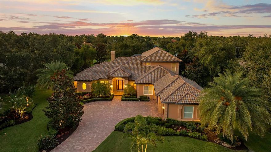 Welcome to your dream home, a sanctuary of elegance and comfort nestled on an exclusive, private street with only nine residences and no neighbors across the way—just the tranquility of a natural preserve. This remarkable property in The Oaks Clubside, with 4 bedrooms, 5 full bathrooms, and 2 half baths, boasts impact windows and doors throughout, providing peace of mind and a quiet, secure environment. Step inside to discover an open floor plan adorned with a blend of rich wood and luxurious travertine floors. Each of the large bedrooms is an en suite retreat, offering privacy and comfort for residents and guests alike. On the first floor you will find a huge master suite, with his-and-her closets, and a luxurious master bathroom that has two separate vanities, a walk-in shower and soaking tub.  The two additional bedrooms are generously sized. The open kitchen features cherry wood cabinets, a granite island and high end stainless steel appliances. The breakfast nook is flooded with natural light and offers a lovely view over the pool. The second story has a fourth en-suite bedroom, and balcony overlooking the golf course and lake. And, for those who love to entertain, the game and media room is designed for fun gatherings of friends. The heart of the home extends outdoors, where you will find an impressive outdoor kitchen area  perfect for grilling and dining alfresco. Enjoy a beautiful, long view of the Heron #14 and the serene lake beyond—a panoramic scene that will take your breath away every day. This home is loaded with thoughtful additions, including three new exterior ceiling fans for comfort on warm days, custom office closet shelving and a secure dog run fence for your furry friends. The garage boasts a durable epoxy floor and hurricane-rated doors. Additional upgrades abound with 4 new AC units with UV lights for optimal air quality, a new roof, two-stage pool pump and new irrigation pump, new tankless Navian water heater to name a few.  You absolutely must see this home to appreciate all it has to offer. Membership in The Oaks Club, Sarasota’s premier golf and country club is required with home ownership.