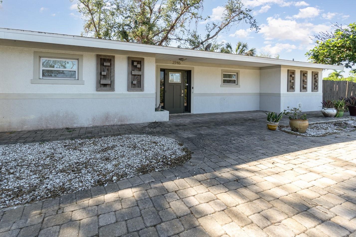 Welcome to your beautifully renovated Southgate home, nestled on a large lot adorned with lovely trees. This exceptional property is ideally located close to beaches, including Siesta Key and St. Armand's Key, as well as vibrant downtown Sarasota. Step inside and be captivated by the spacious layout of this 3-bedroom, 3-bathroom gem, complete with a sprawling backyard perfect for outdoor activities. The thoughtful split floor plan ensures privacy and comfort. Inside, you’ll find stunning new flooring and a modern kitchen featuring sleek stainless steel appliances. The kitchen is a culinary dream with a suspended exhaust hood over the island cooktop and exquisite stone countertops. Designer light fixtures add a touch of elegance throughout the home. The expansive open floor plan is highlighted by a cozy wood-burning fireplace, creating a warm and inviting atmosphere. Don’t miss the opportunity to make this remarkable home your own!