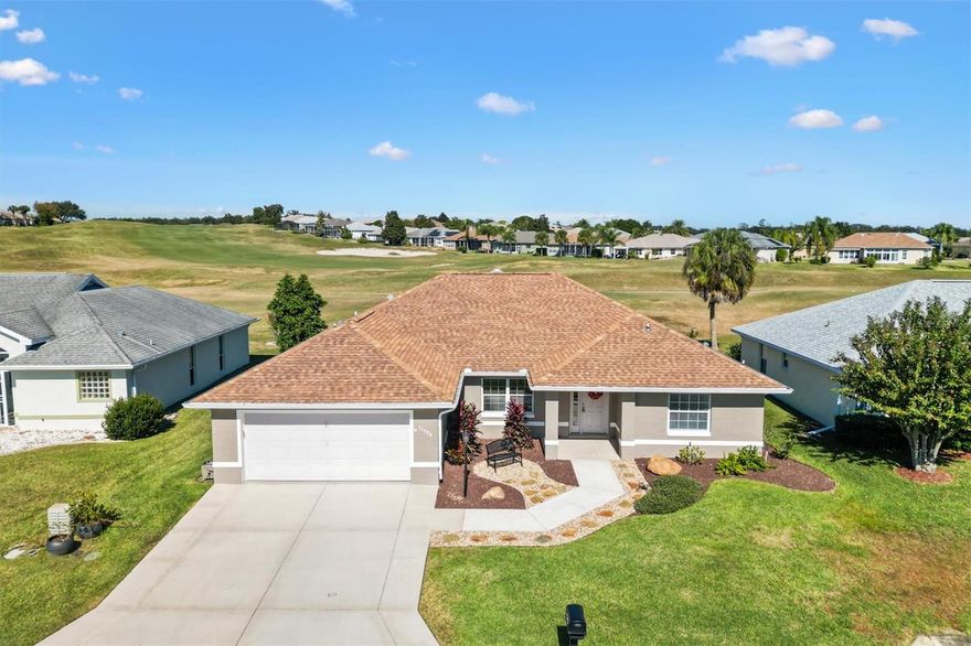 One or more photo(s) has been virtually staged. Located in the Beautiful 55+ Gated Golf community of STONECREST, this stunning home offers an unbeatable combination of comfort, convenience, and lifestyle. Adjacent to THE VILLAGES, Florida, the community provides endless amenities and golf cart access to shopping, dining, and medical facilities.  This remodeled CONCRETE/BLOCK/STUCCO home features 3 bedrooms and 2 bathrooms and is positioned directly on the GOLF COURSE, offering fabulous, unobstructed views of the rolling hills. Updates include a 2017 ROOF, 2011 HVAC system, 2025 WATER HEATER, and a COMPLETELY REMODELED KITCHEN AND BATHROOMS 2023. The interior showcases beautiful QUARTZ countertops, abundant cabinetry, stainless steel appliances, HARDWOOD floors in the living and dining areas, and LAMINATE flooring throughout the rest of the home. High ceilings add to the open, airy feel. A large lanai spans the back of the home, with sliding doors from the primary bedroom, living room, and breakfast nook leading to a spacious 55 x 20 foot CONCRETE PATIO, perfect for enjoying peaceful mornings or entertaining with a sweeping golf course backdrop.   Could easily add a birdcage should one desire.  Stonecrest offers a rich array of amenities and a vibrant, active lifestyle. If you haven’t visited this exceptional community, now is the time to schedule a private viewing and start enjoying retirement at an affordable price.